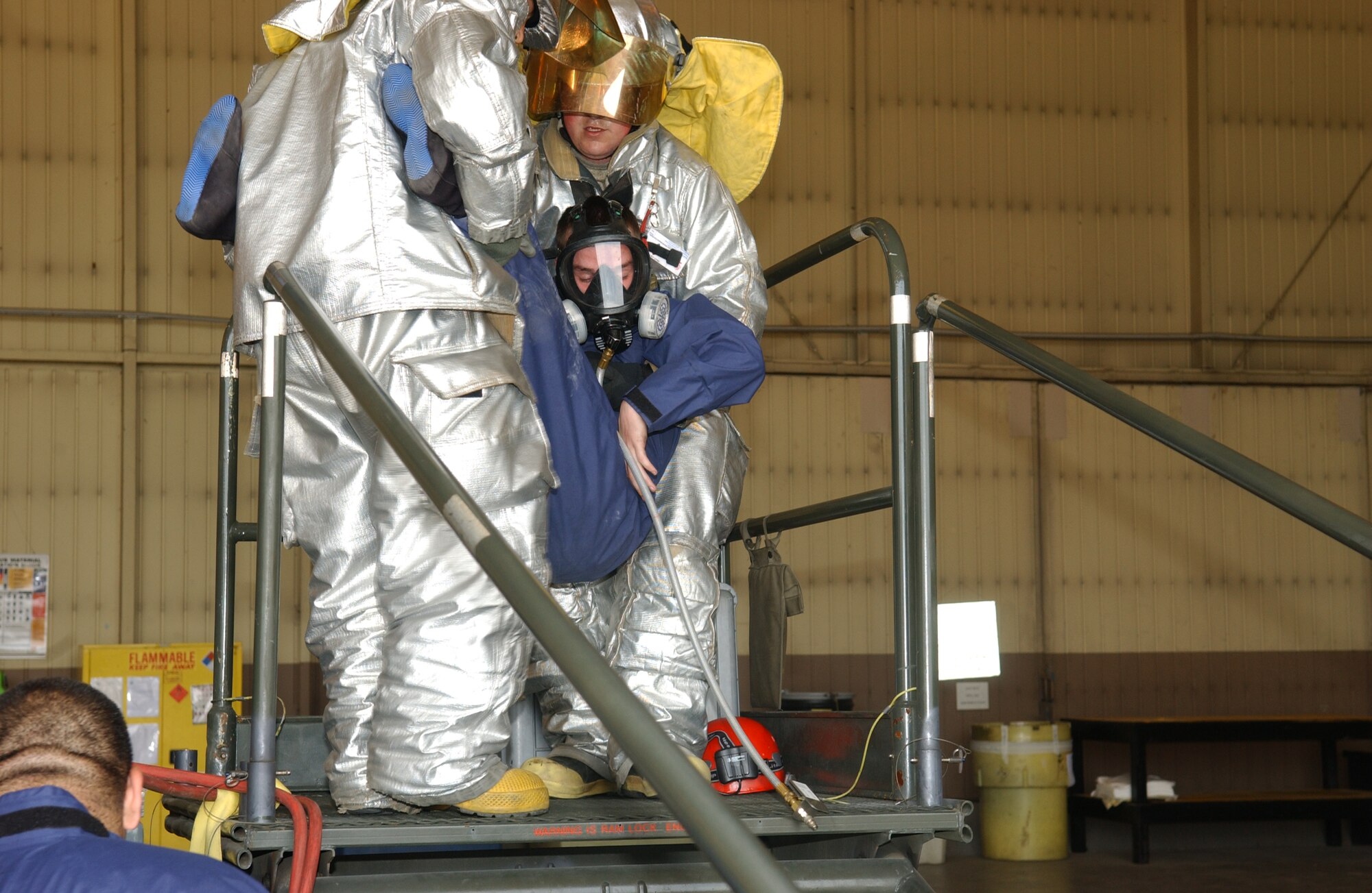 OSAN AIR BASE, Republic of Korea - Senior Airmen Michael Teauge, 51st Maintenance Squadron fuel system repair technician is carried to a safe location after being pulled from a confined space trainer on June 15 during an emergency extraction exercise.  The trainer was used in an extraction exercise that tested the ability of the maintainers as well as 51st Civil Engineer fire department in the ability to remove individuals from confined spaces.  (U.S. Air Force photo by Staff Sgt. Christopher A. Marasky)
