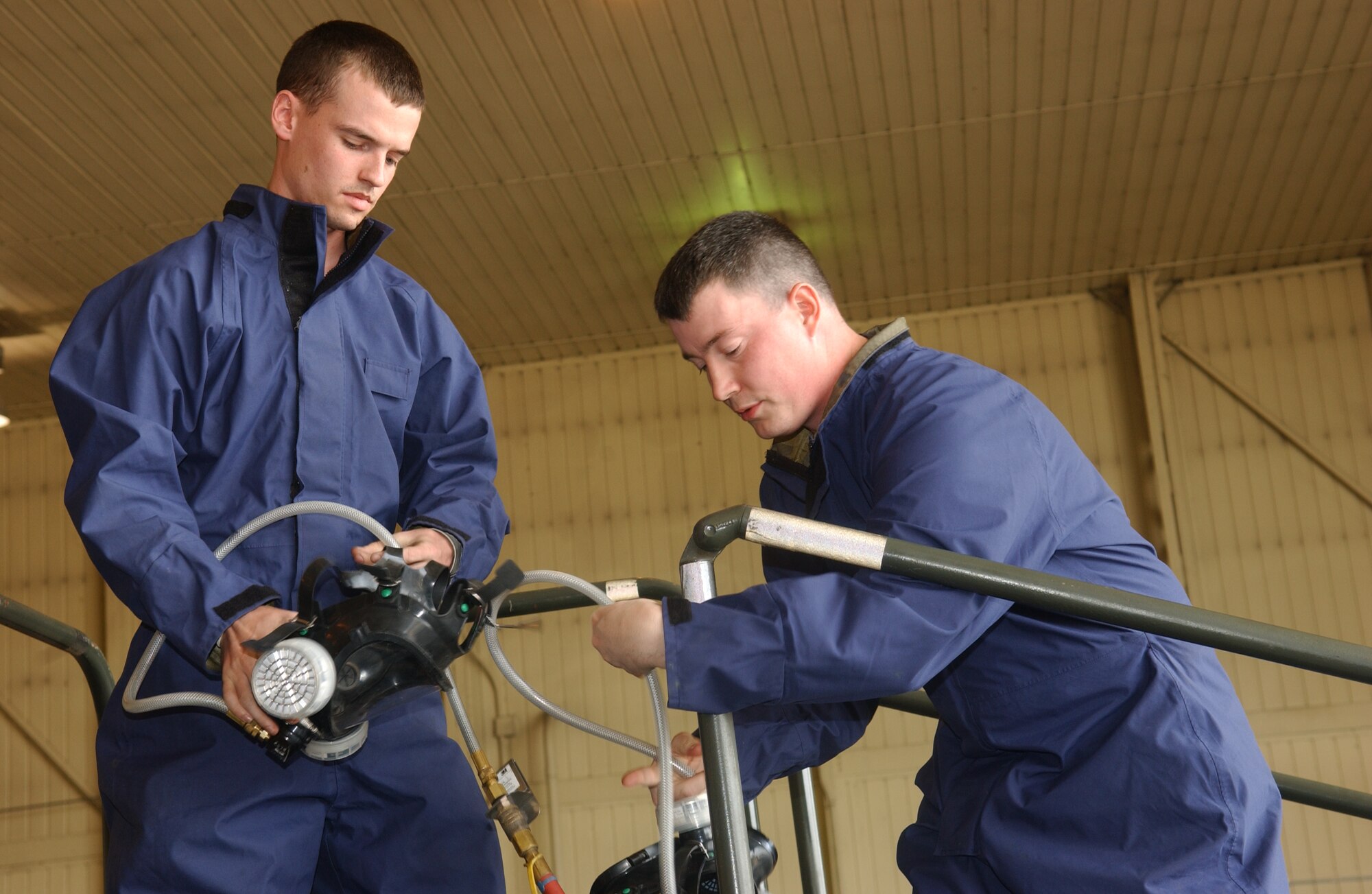 OSAN AIR BASE, Republic of Korea - Senior Airmen Michael Teauge(Left) and Charles Goodson(Right), 51st Maintenance Squadron fuel maintenance technicians prepares air lines for tank entry into a confined space trainer on June 15.  The trainer was used in an extraction exercise that tested the ability of the maintainers as well as 51st Civil Engineer fire department in the ability to remove individuals from confined spaces.  (U.S. Air Force photo by Staff Sgt. Christopher A. Marasky)