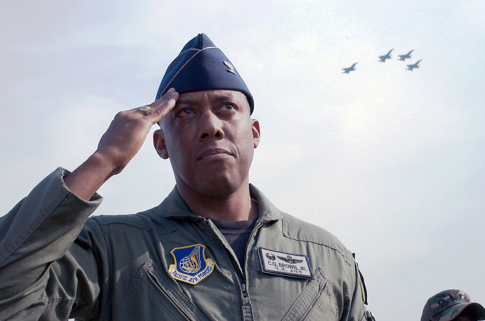 Col. C. Q. Brown, 8th Fighter Wing commander, salutes during a commemoration at Kunsan Air Base, South Korea, June 19 as a missing man formation, flown by members of the wing, passes by overhead.  The ceremony was to honor the memory of Brig. Gen. Robin Olds, who passed away recently. General Olds was a triple ace fighter pilot in World War II and Vietnam and a former commander of the then 8th Tactical Fighter Wing at Kunsan.  (U.S. Air Force Photo/Senior Airman Barry Loo)