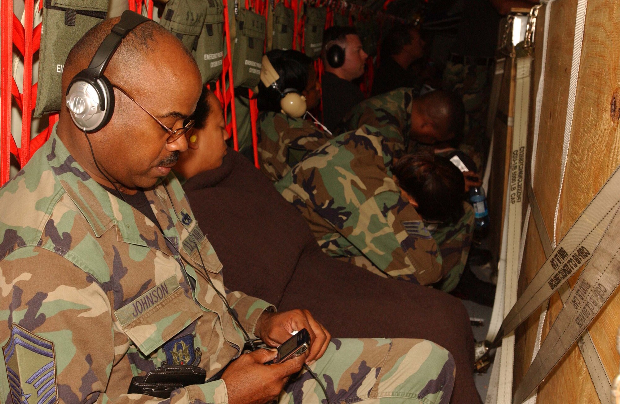 RAMSTEIN AIR BASE, Germany -- Senior Master Sgt. Frederic Johnson, 69th Aerial Port Squadron superintendent of special handling, wears headphones during the nine-hour flight returning from Germany June 17. He and 30 other 69th APS Reservists spent their two-week annual tour supporting the active duty 723rd Aerial Port Squadron. The mission included round-the-clock cargo shifts, pallet construction and passenger terminal support. (U.S. Air Force photo/Staff Sgt. Amaani Lyle)