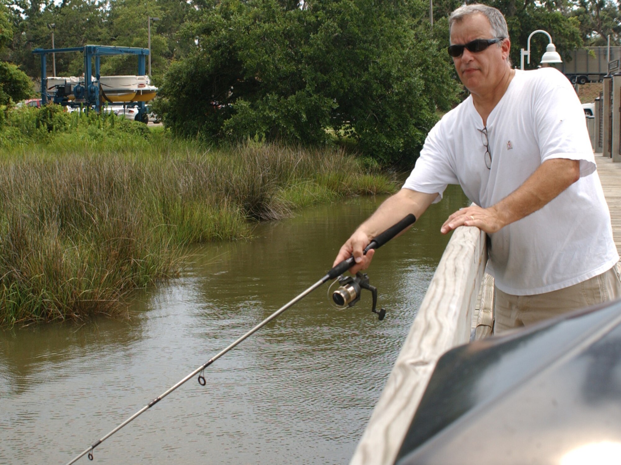 Marty Dimauro, 81st Communications Squadron, fishes from the marina pier.  Pontoon boat rides were also offered during the day.  (U. S. Air Force photo by Kemberly Groue)
