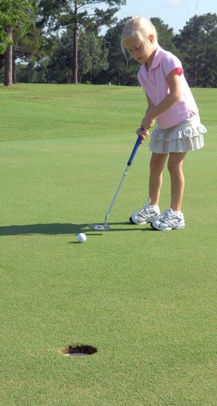 Chole Gilliland, daughter of Capt. Scott Gilliland, attempts a putt during the Quiet Pines Kids Golf Tournament June15. (U.S. Air Force photo by Senior Airman Angelita Lawrence)