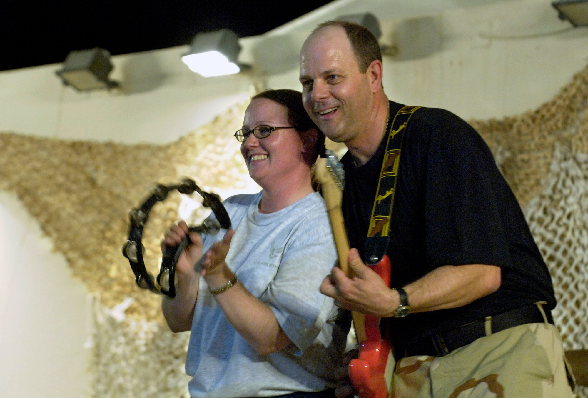 Tech. Sgt. Jennifer Butts (left) sits in with the band.  Two U.S. Central Air Forces expeditionary bands that debuted under their new names "Live Round" and "Thunder Roll" held a combined kick-off concert June 16 for deployed servicemembers at an air base in Southwest Asia.  Sergeant Butts is the NCO in charge of the 379th Medical Logistics Squadron.  (U.S. Air Force photo/Master Sgt. Jim Varhegyi)