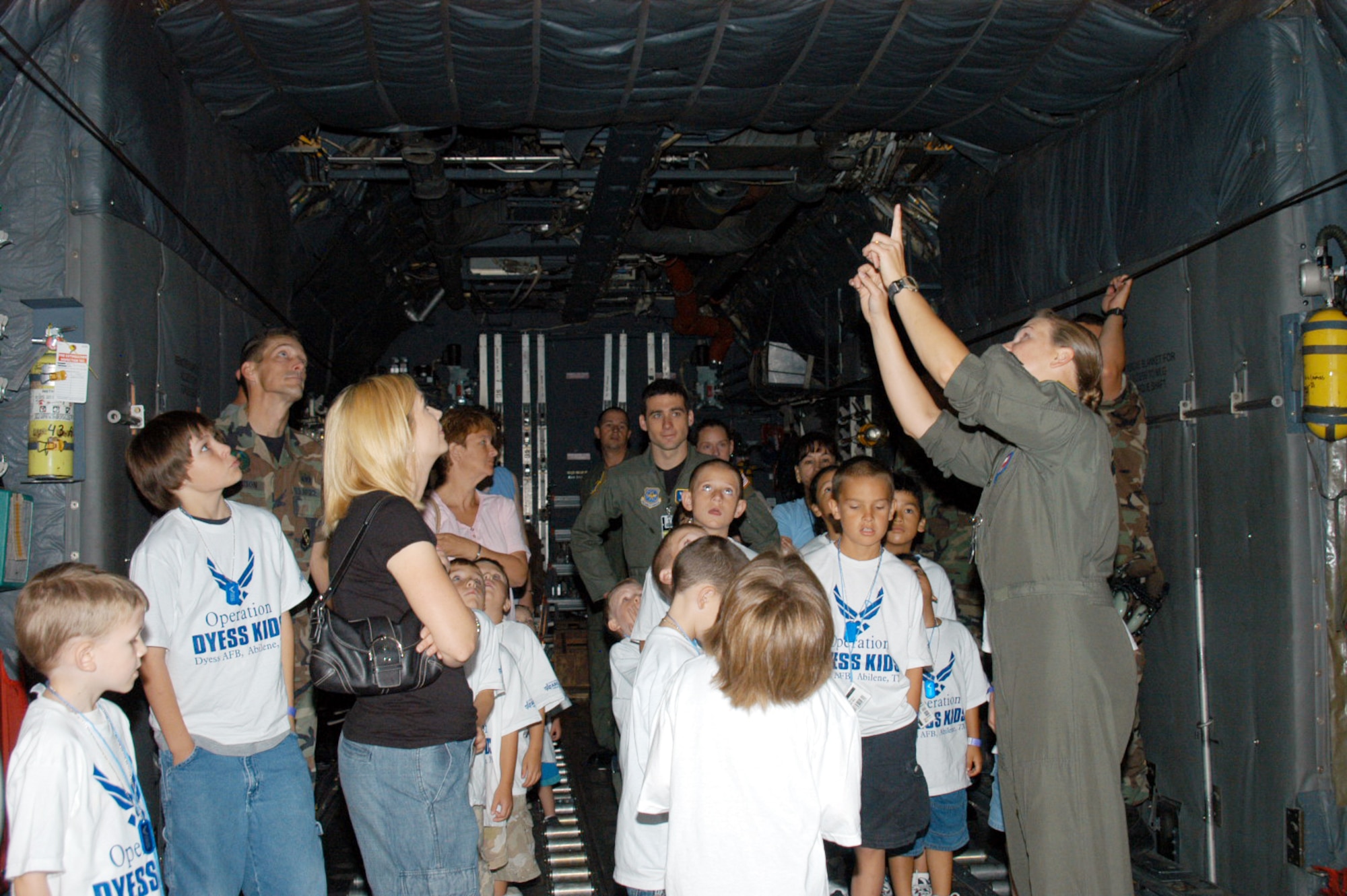 Capt. Charlotte Jackson (right, flight suit), 39th Airlift Squadron, shows military children the inside of a C-130 at Operation Dyess Kids June 15. (U.S. Air Force photo/Airman 1st Class Carolyn Viss)                                