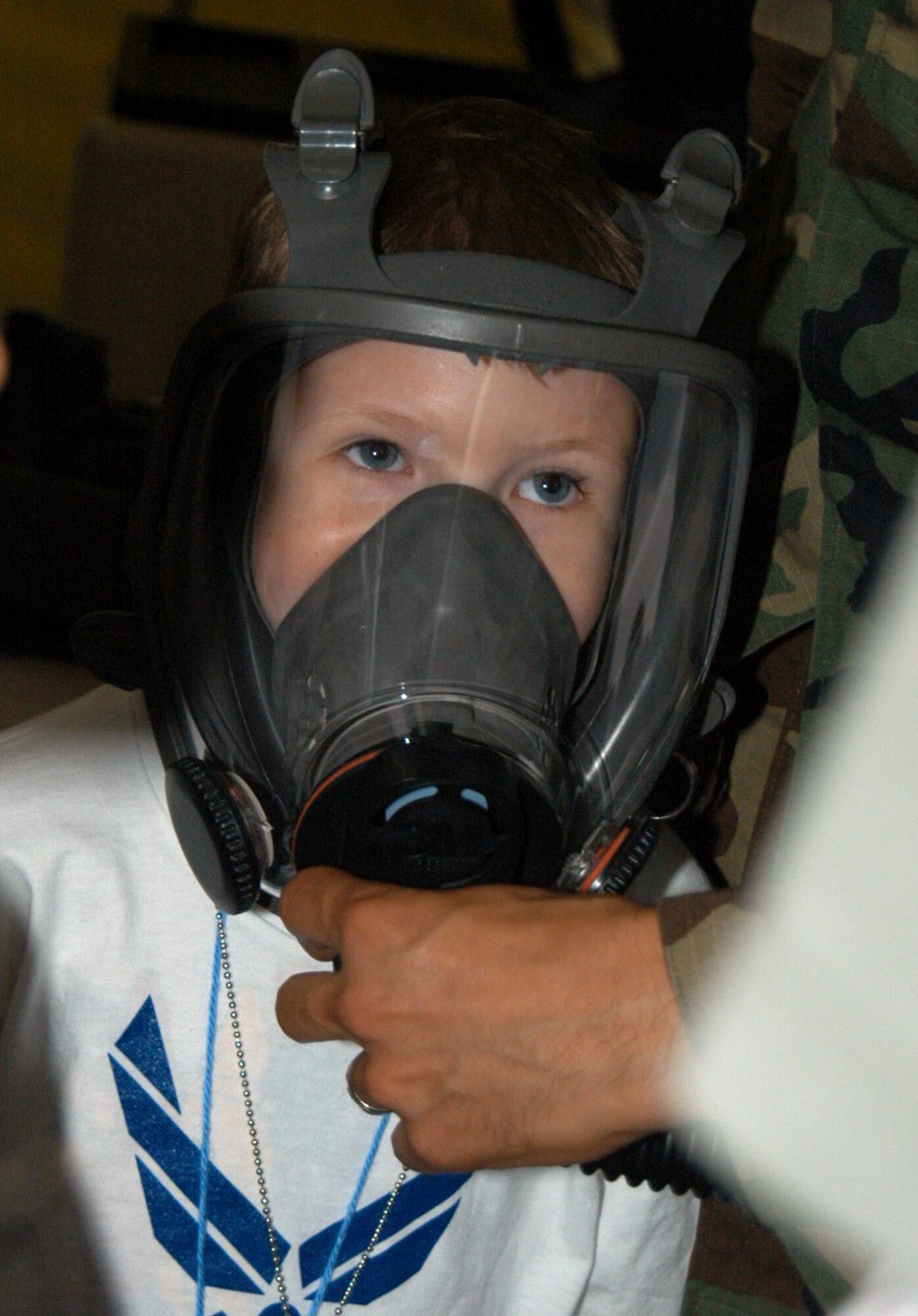 Eli Jackson, 7, tries on a gas mask similar to what his deployed father, a Dyess firefighter, would wear as he "deploys" with Operation Dyess Kids June 15. (U.S. Air Force photo/Airman 1st Class Carolyn Viss)                   
