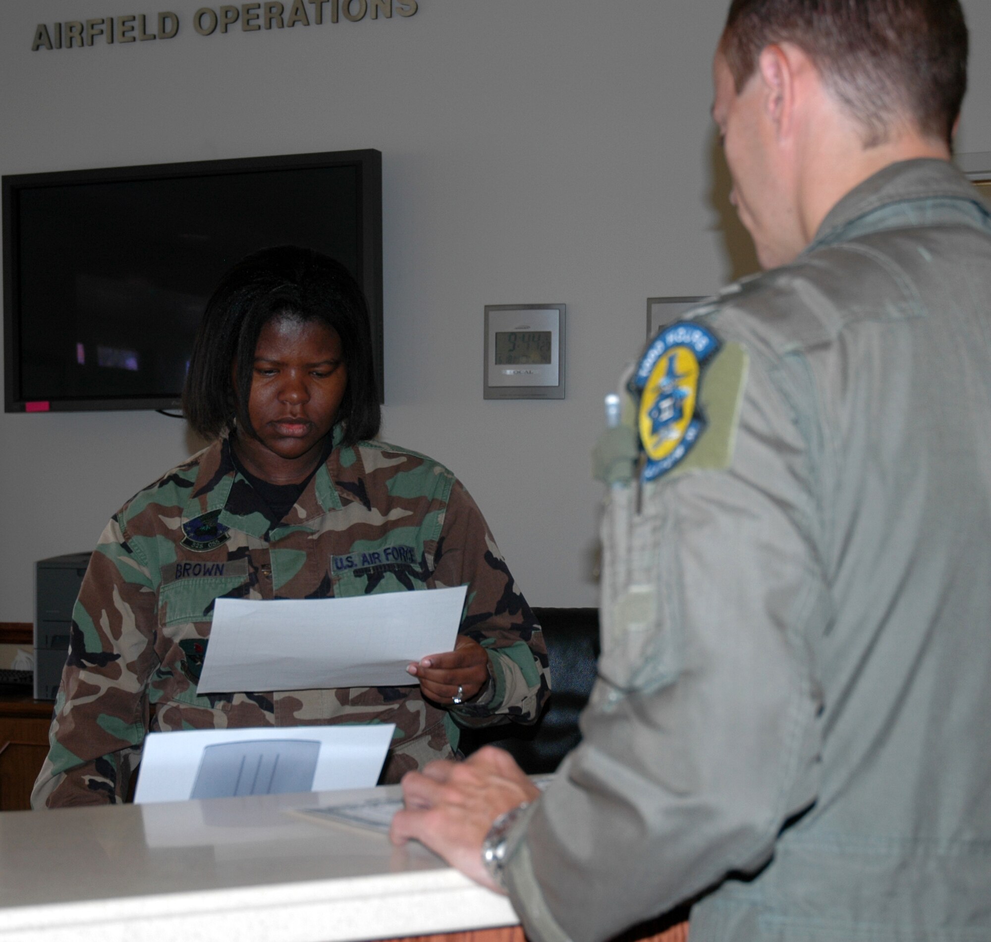 Senior Airman Jessica Brown, 325th Operations Support Squadron airfield management operations shift supervisor, helps a visiting pilot file his flight plan. Her flight logs an average of 2,000 plans a month that are forwarded to the Federal Aviation Administration for approval.