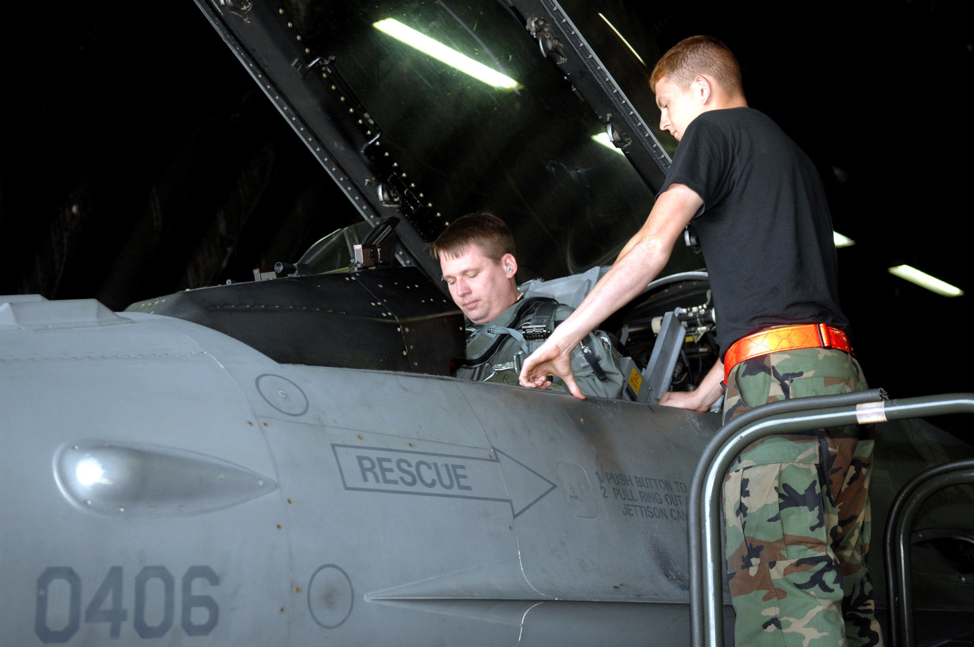 Airman 1st Class Daren Cantu assists Lt. Col. Bartz Sykes with some last minute tasks June 11 before the pilot departs Spangdahlem Air Base, Germany, in his F-16 Fighting Falcon, en route to Nellis Air Force Base, Nev., due to the base's runway closure. Airman Cantu is assigned to the 52nd Aircraft Maintenance Squadron and Colonel Sykes is with the 22 Fighter Squadron. (U.S. Air Force photo/Senior Airman Josie Kemp) 