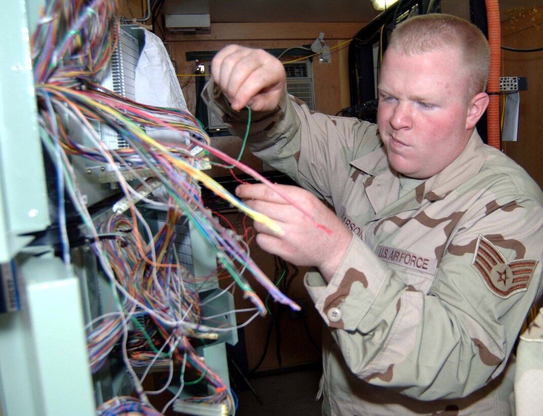 Staff Sgt. Matthew Pearson splices copper wires used for phone lines at Sather Air Base, Iraq. The cable he is splicing contains 400 wires, each requiring individual attention. Sergeant Pearson is a cable and antenna technician assigned to the 447th Expeditionary Communication Squadron. (U.S. Air Force photo/Tech. Sgt. Russell Wicke)