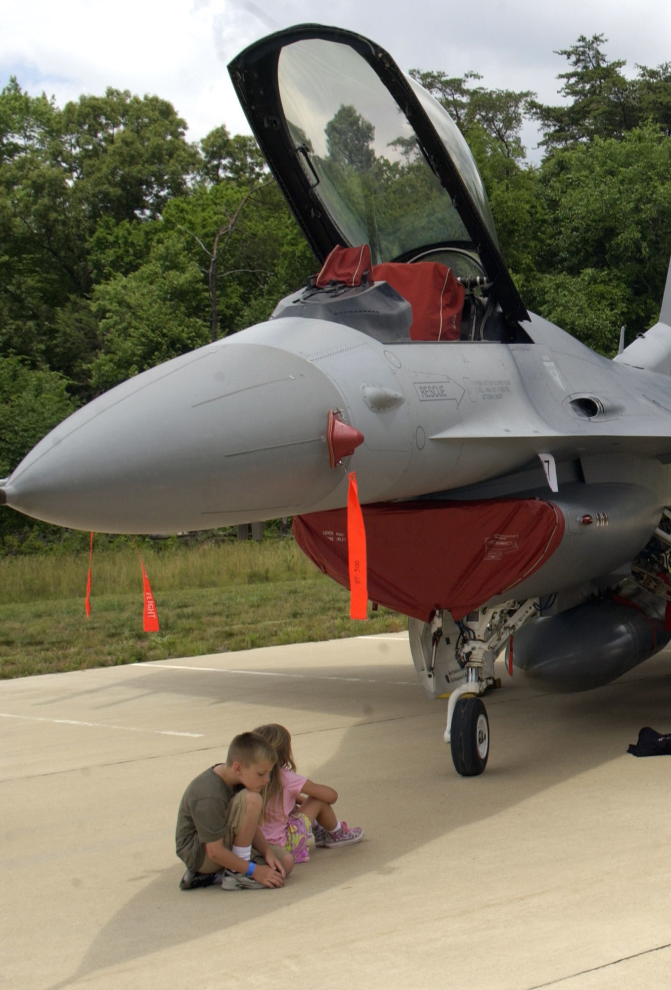 Two visitors relax in the shade of an F-16 Fighting Falcon on display during the "Reach for the Sky" family day at the National Air and Space Museum's Udvar-Hazy Center in Chantilly, Va.  The airshow featured several static civilian and military aircraft in addition to the museum's vast array of air and space displays. More than 17,000 people attended the event, which also honored the Air Force's 60th Anniversary as a separate service.  (U.S. Air Force photo/Staff Sgt. J.G. Buzanowski) 