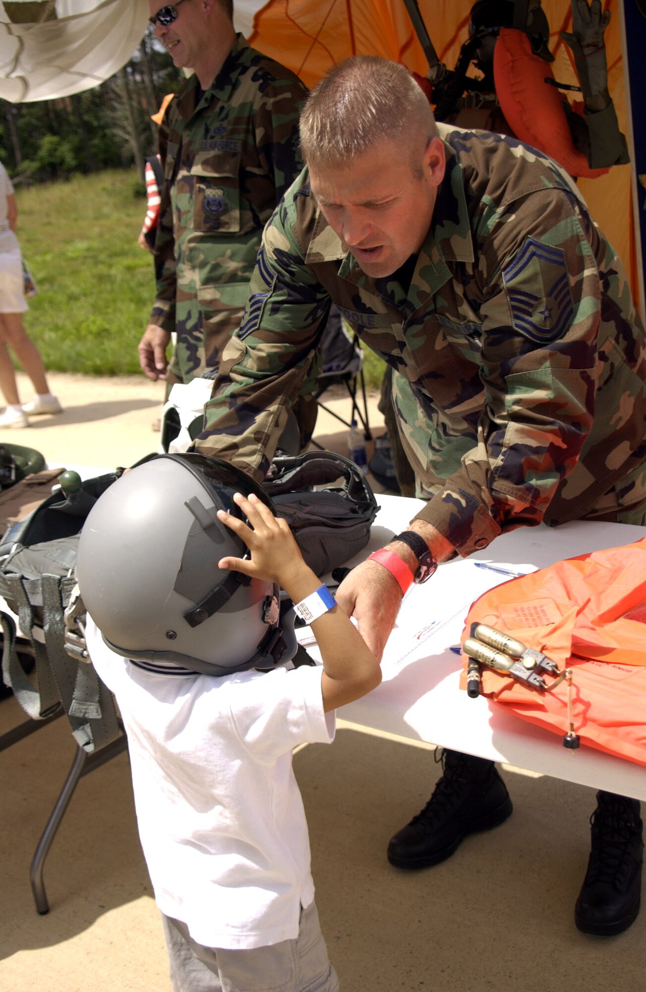Senior Master Sgt. Ray Poole helps 4-year-old Rohan Kettish try on a pilot's helmet during the "Reach for the Sky" family day at the National Air and Space Museum's Udvar-Hazy Center in Chantilly, Va.  The airshow featured several static civilian and military aircraft in addition to the museum's vast array of air and space displays. More than 17,000 people attended the event, which also honored the Air Force's 60th Anniversary as a separate service.  Sergeant Poole is the life support superintendent with the Pennsylvania Air National Guard's 171st Air Refueling Wing. (U.S. Air Force photo/Staff Sgt. J.G. Buzanowski) 