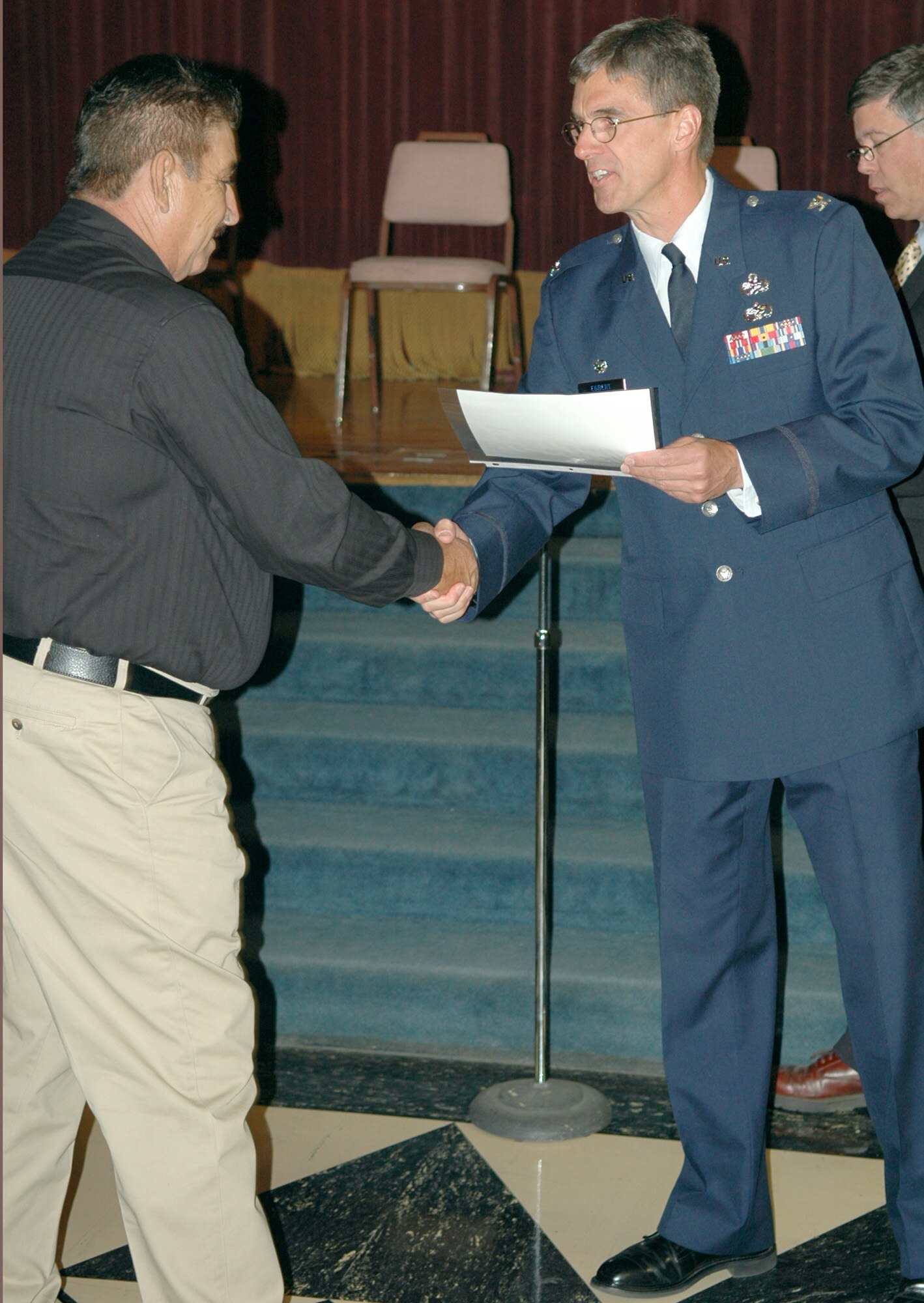 SPOKANE, Wash. -- Col. Robert Egbert, 92nd Maintenance Group commander at Fairchild Air Force Base, Wash., presents a naturalization certificate to one of 139 new U.S. citizens at an induction ceremony held June 14 here. (U.S. Air Force photo/Joe Wiles)
