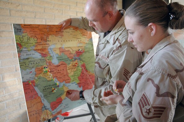 Staff Sgt. Kenny Kindrick, 90th Logistics Readiness Squadron, and Staff Sgt. Rachael Cover, 90th LRS, place tacks onto a world map signifying where they’ve deployed during the barbeque for deployed families and returnees June 6 at the base lake pavilion. More than 100 Airmen and families enjoyed hamburgers, hot dogs, snacks and desserts during the event while swapping deployment stories with their peers (Photo by 2nd Lt. Lisa Meiman).