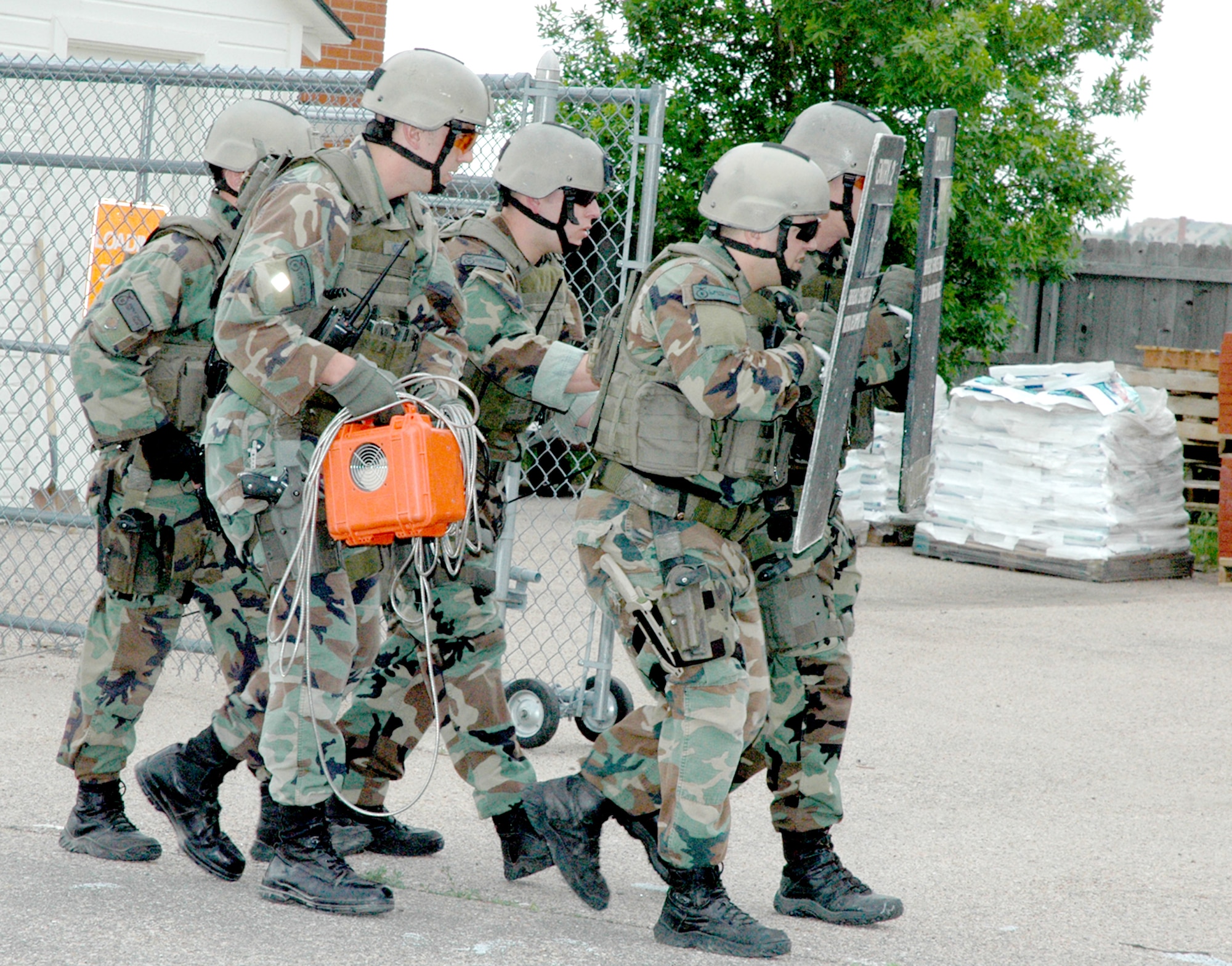 Members of the 90th Tactical Response Force gear up, get ready and enter the hostage area to deliver a telephone requested by the hostages.