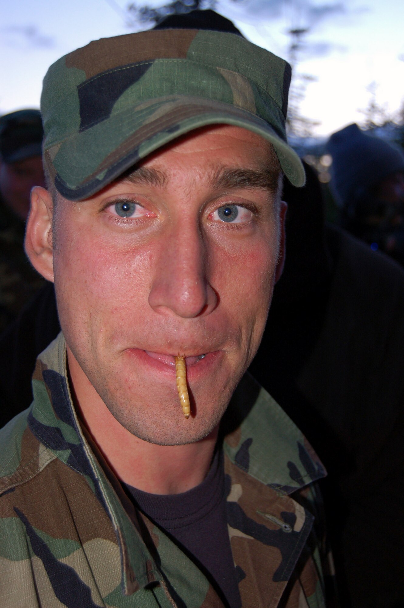 Staff Sgt. Michael Garcia, a Survival, Evasion, Resistance, and Escape specialist and water survival instructor, slurps down a grub for supper June 11 as part of the SERE Challenge. Finding anything available to eat and overcoming food aversions is a basic skill set of SERE. (U.S. Air Force photo/Staff Sgt. Matthew Rosine)