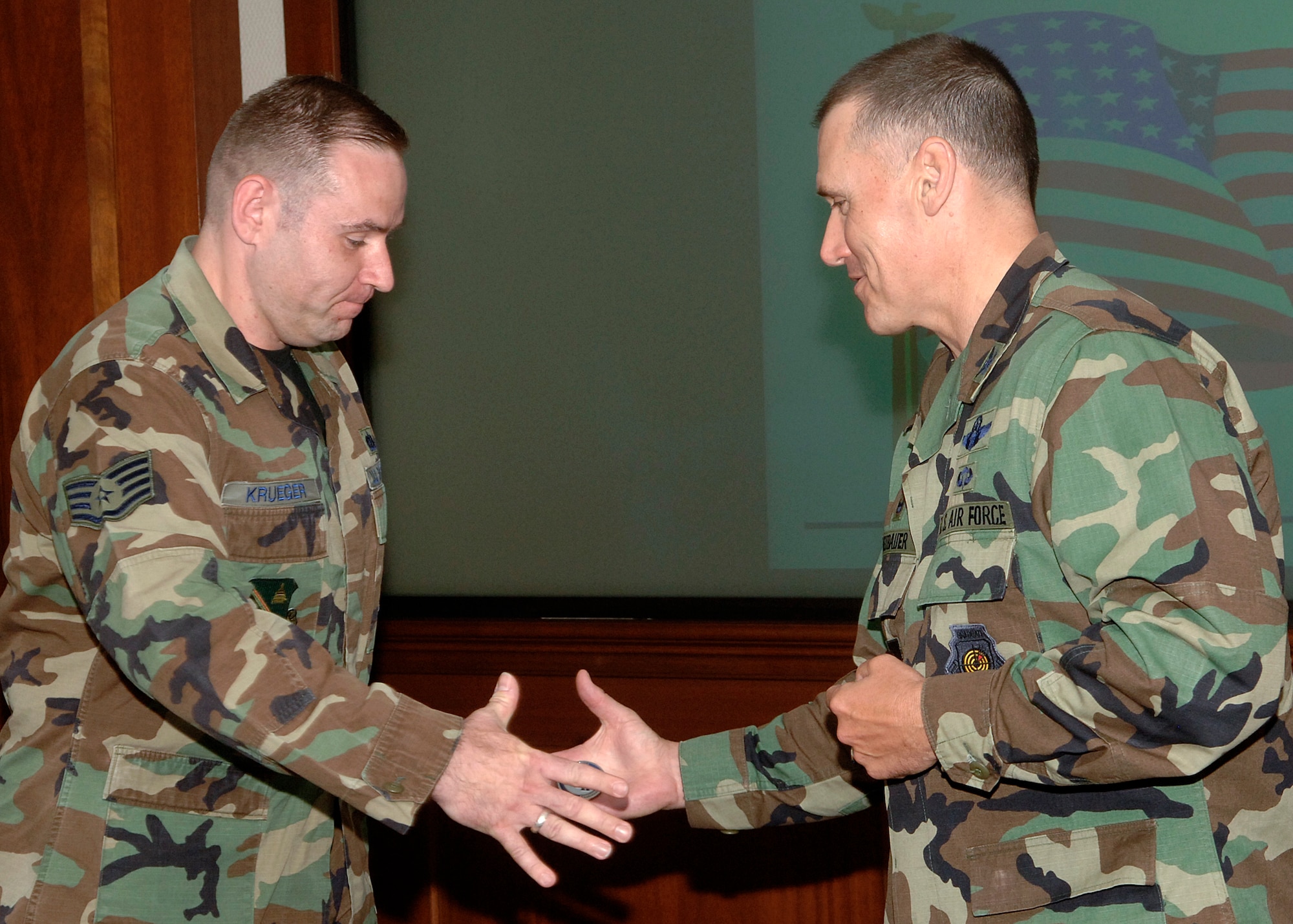 11th Wing Commander Col. Kurt F. Neubauer “coins” Staff Sgt. Peter Krueger, Pentagon Military Personnel Flight information manager, at wing standup June 13.  Sergeant Krueger was publicly recognized for his impressive contributions to the MPF mission, as well as earning an outstanding rating in the January Unit Compliance Inspection. (U.S. Air Force photo by Thomas Dennis)