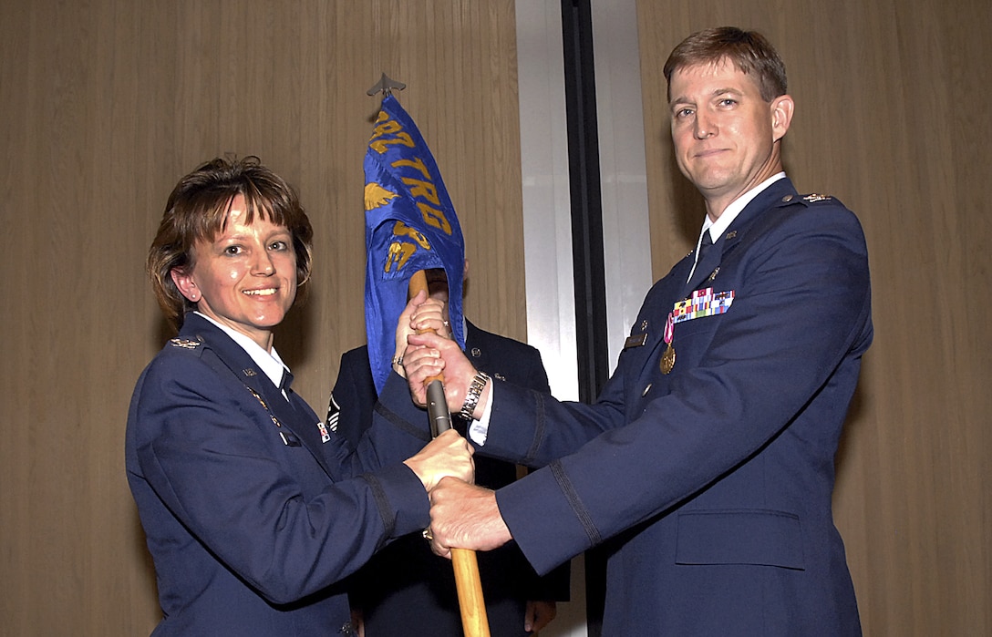 Col. Nancy Dezell, 882nd Training Group commander, accepts the guidon from Col. Thompson, outgoing 381st Training Squadron commander, June 18 at the 381st TRS change-of-command ceremony. (U.S. Air Force photo/Harry Tonemah)