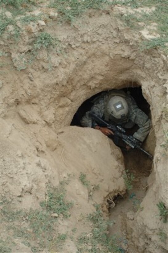 U.S. Army Spc. William Fowler enters a cave during search and clear operations near the village of Kuz Khadow Kheyl, Afghanistan, on June 8, 2007.  Fowler is attached to the Armyís Delta Company, 2nd Battalion, 508th Parachute Infantry Regiment.  
