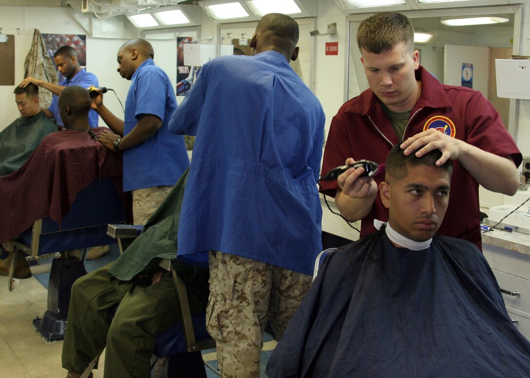 Corporal Hollis Versyp, of Abilene, Texas, an administration clerk with the 22nd Marine Expeditionary Unit Command Element, cuts a sailor's hair in the barbershop aboard the USS Kearsarge, June 20, 2007. The 22nd MEU consists of its Ground Combat Element, Battalion Landing Team, 3rd Battalion, 8th Marine Regiment; Aviation Combat Element, Marine Medium Helicopter Squadron 261; Logistic Combat Element, Combat Logistics Battalion 22; and its Command Element. (Official Marine Corps photo by Cpl. Peter R. Miller)::n::
