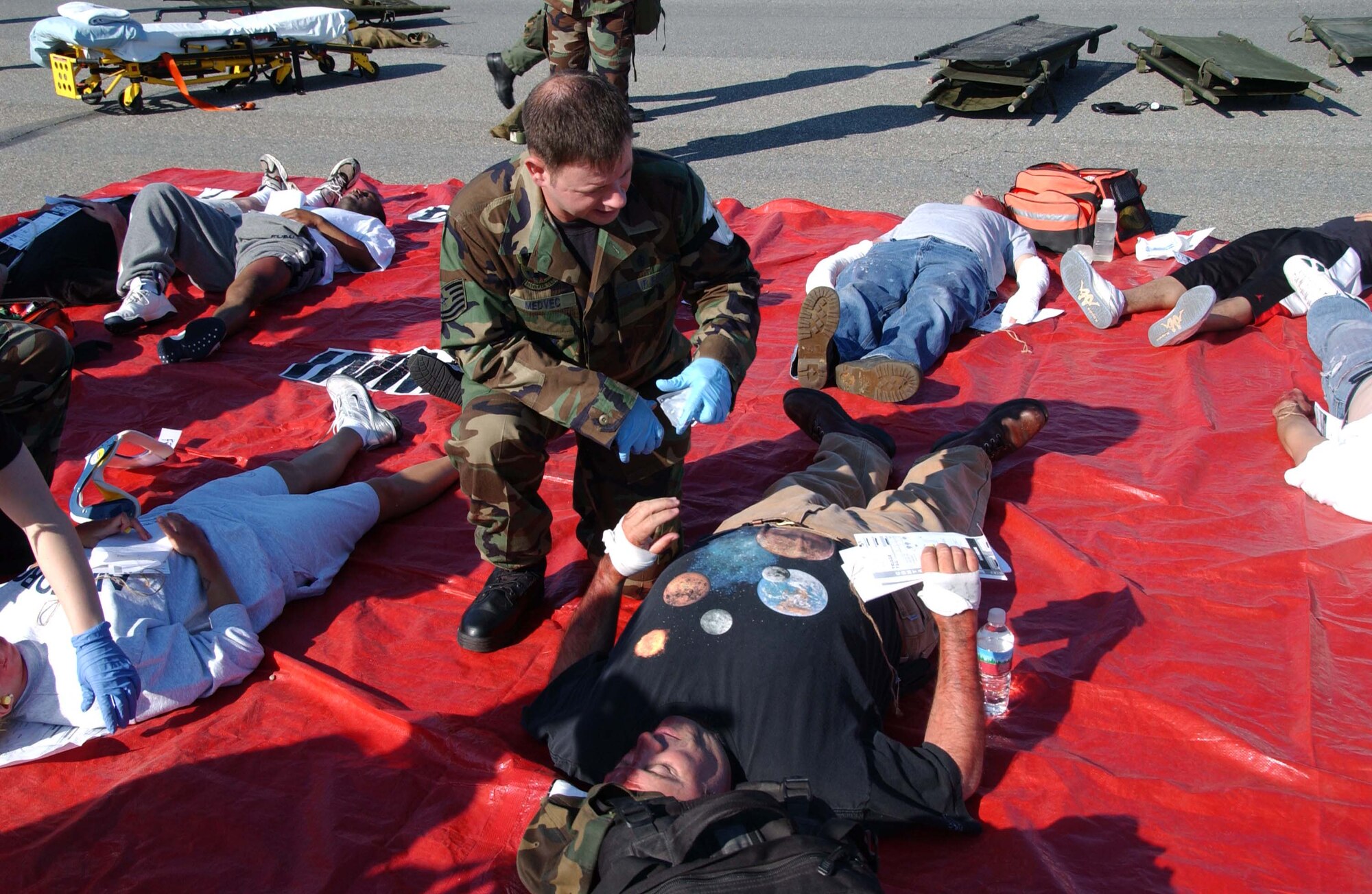 EIELSON AIR FORCE BASE, Alaska --  Tech. Sgt. Landru Medvec, 354th Medical Operations Squadron, performs care on the bystander who became injured during a simulated F-16 crash June 19 here. Eielson held an emergency management exercise to help in the readiness and response in case of unforeseen events, members of the medical group tend to those that are injured and to make sure they get the attention and care they need. (U.S. Air Force photo by Airman 1st Class Christopher Griffin)