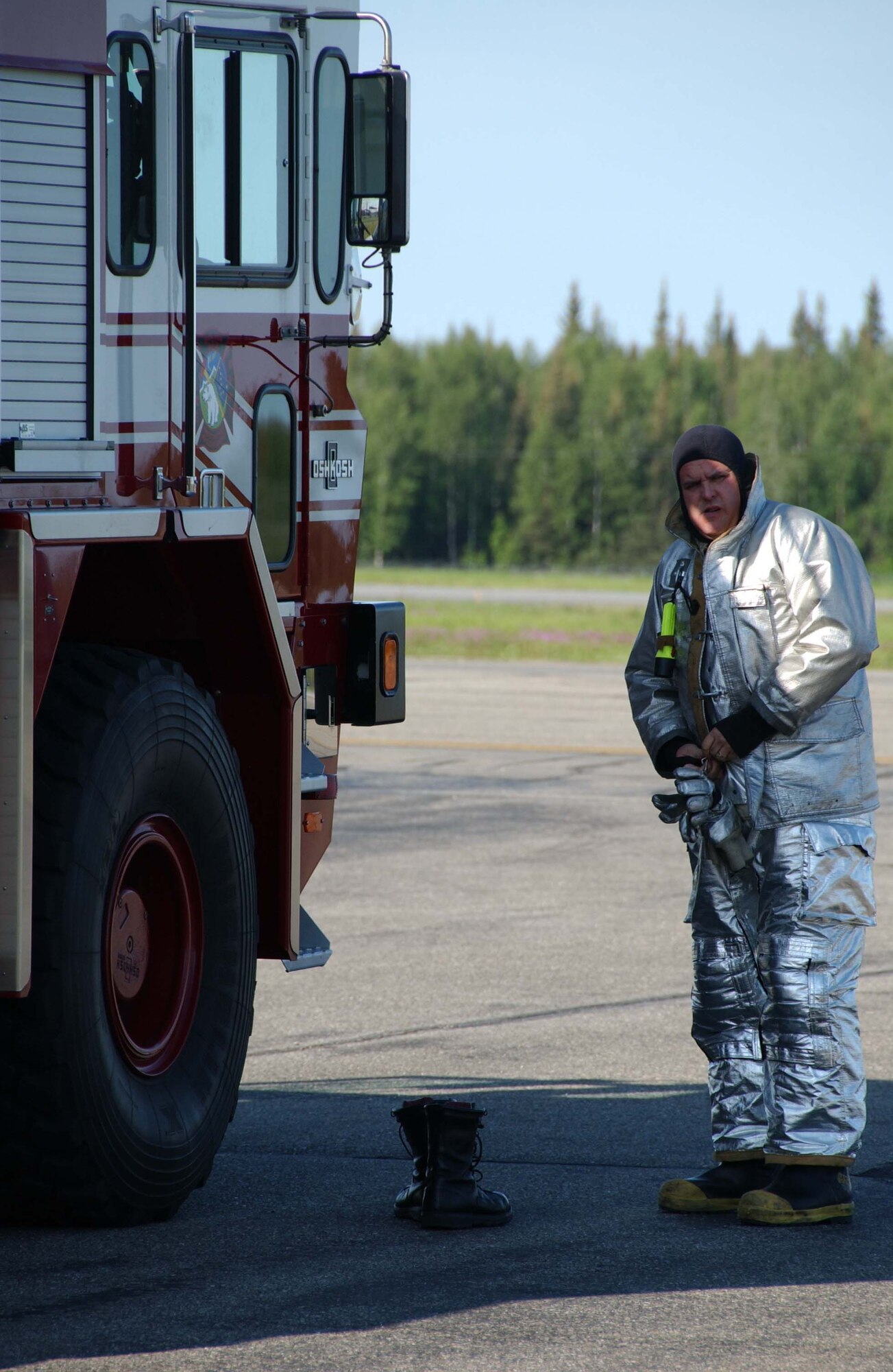 EIELSON AIR FORCE BASE, Alaska - A 354th Civil Engineer Squadron fireman suits up to respond to a simulated F-16 crash June 19 here. Eielson held an Emergency Management Exercise simulating an aircraft crashing during the upcoming Open House which will help in the response and reaction for unforeseen events. 
 (U.S. Air Force photo by Airman 1st Class Christopher Griffin)