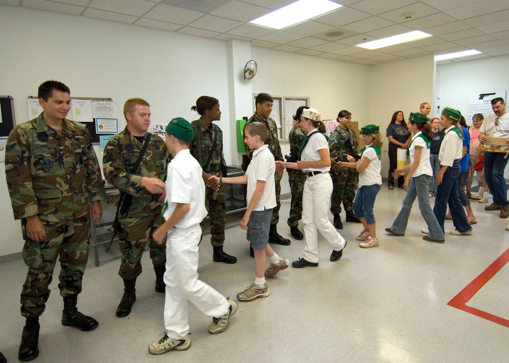 EDWARDS AIR FORCE BASE, Calif. -- 95th Security Forces Squadron Airmen shake the hands of 4-H Club members during a security forces recognition at the 95th SFS headquarters building June 15. The 4-H Club donated letters, magazines, games and goodies for the 95th SFS troops deployed downrange. The 4-H Club is a youth organization administered by the Cooperative Extension System of the Department or Agriculture. (Photo by Edward Cannon)