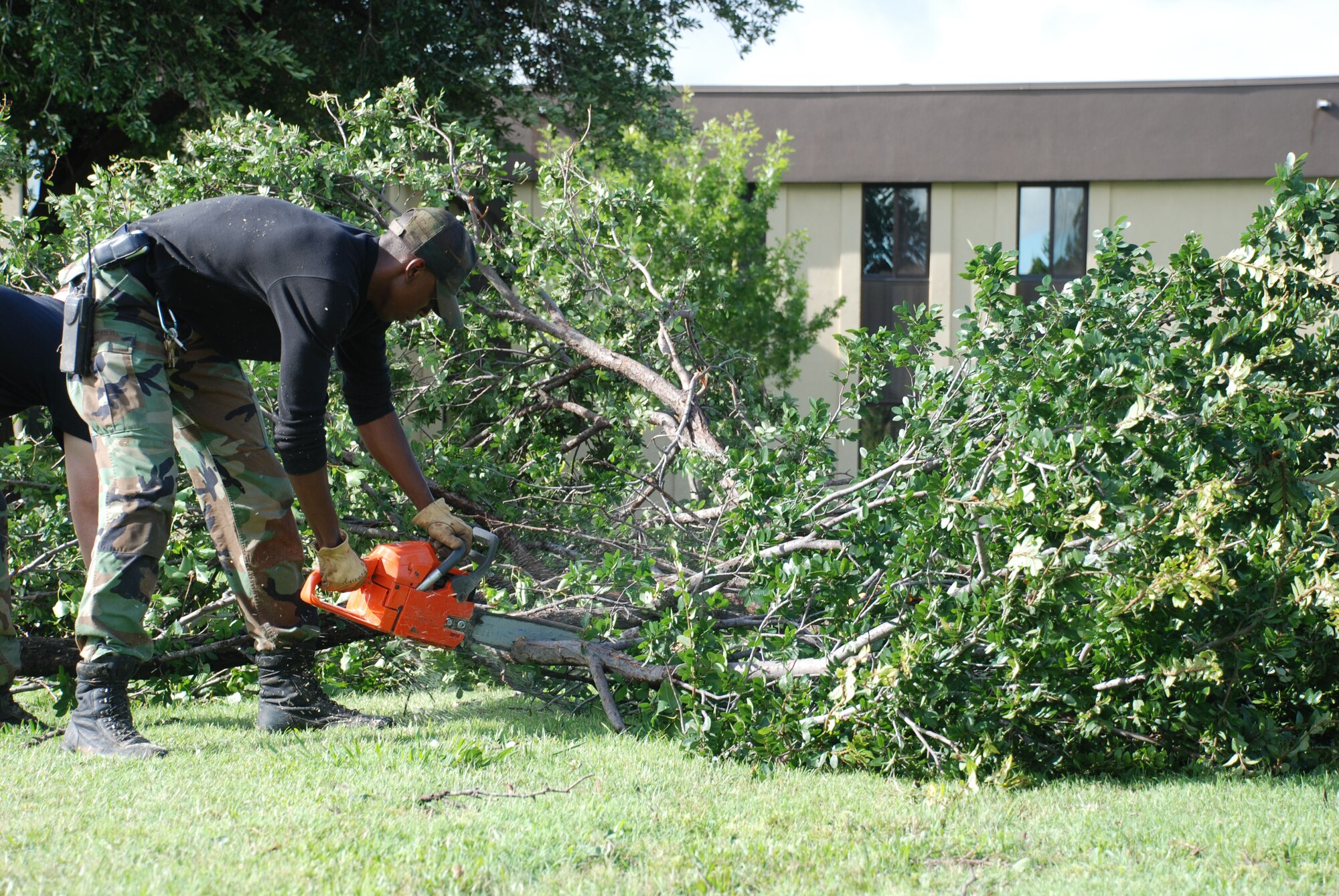 Airman 1st Class Alan Franklin, 82nd Civil Engineer Squadron, cuts into a fallen tree branch June 20 outside Bldg. 400. The 82nd CES, Sheppard fire and rescue services and 82nd Security Forces Squadron raced into action after thunderstorms assaulted Sheppard with 85 mph winds. Electricity was knocked out across base, but was quickly restored. (U.S. Air Force photo/Victoria Brayton)