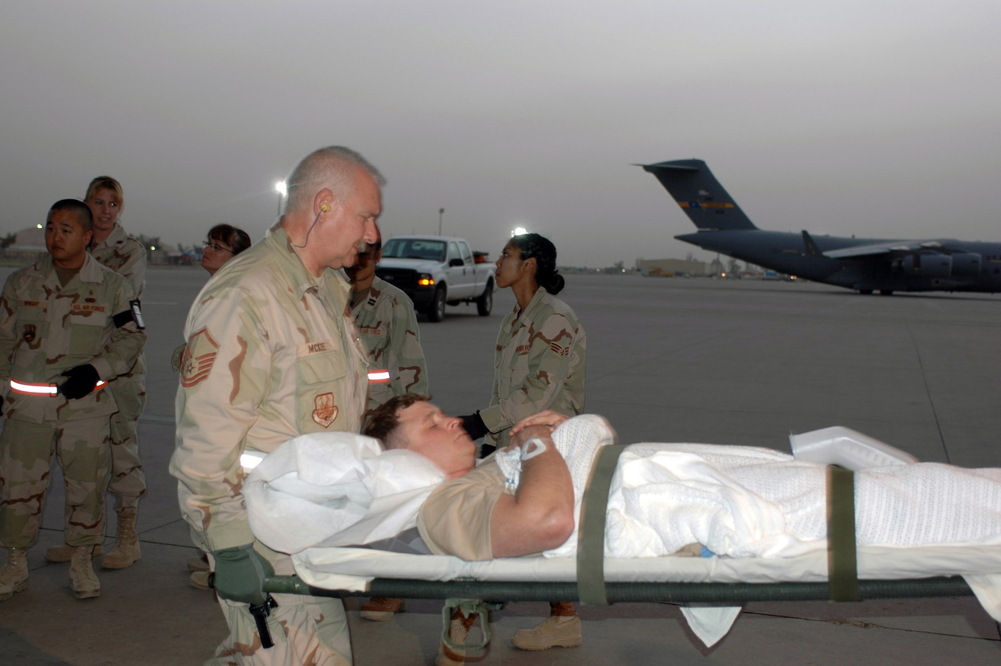 Master Sgt. Duane McKee helps carry a wounded warrior to a C-130 Hercules June 13 at Balad Air Base, Iraq. A 379th Expeditionary Aeromedical Evacuation Squadron team picked up patients at Al Asad Air Base, Iraq, and here to take to Southwest Asia for further care. Sergeant McKee is assigned to the 332nd Expeditionary Operations Support Squadron, (U.S. Air Force photo/Staff Sgt. Cassandra Locke)