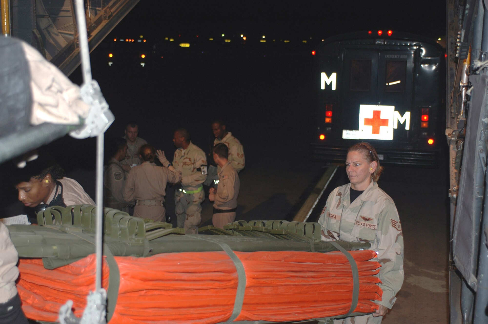 Staff Sgt. Christine Penska (right) helps Staff Sgt. Christine Hall unload a litter to transport patients from the tarmac to the C-130 aircraft June 13 at Balad Air Base, Iraq. Patients were sent to a base in Southwest Asia for further care. Sergeant Penska is assigned to the 332nd Operations Support Squadron and Sergeant Hall is assigned to the 379th Expeditionary Aeromedical Evacuation Squadron. (U.S. Air Force photo/Staff Sgt. Cassandra Locke)
