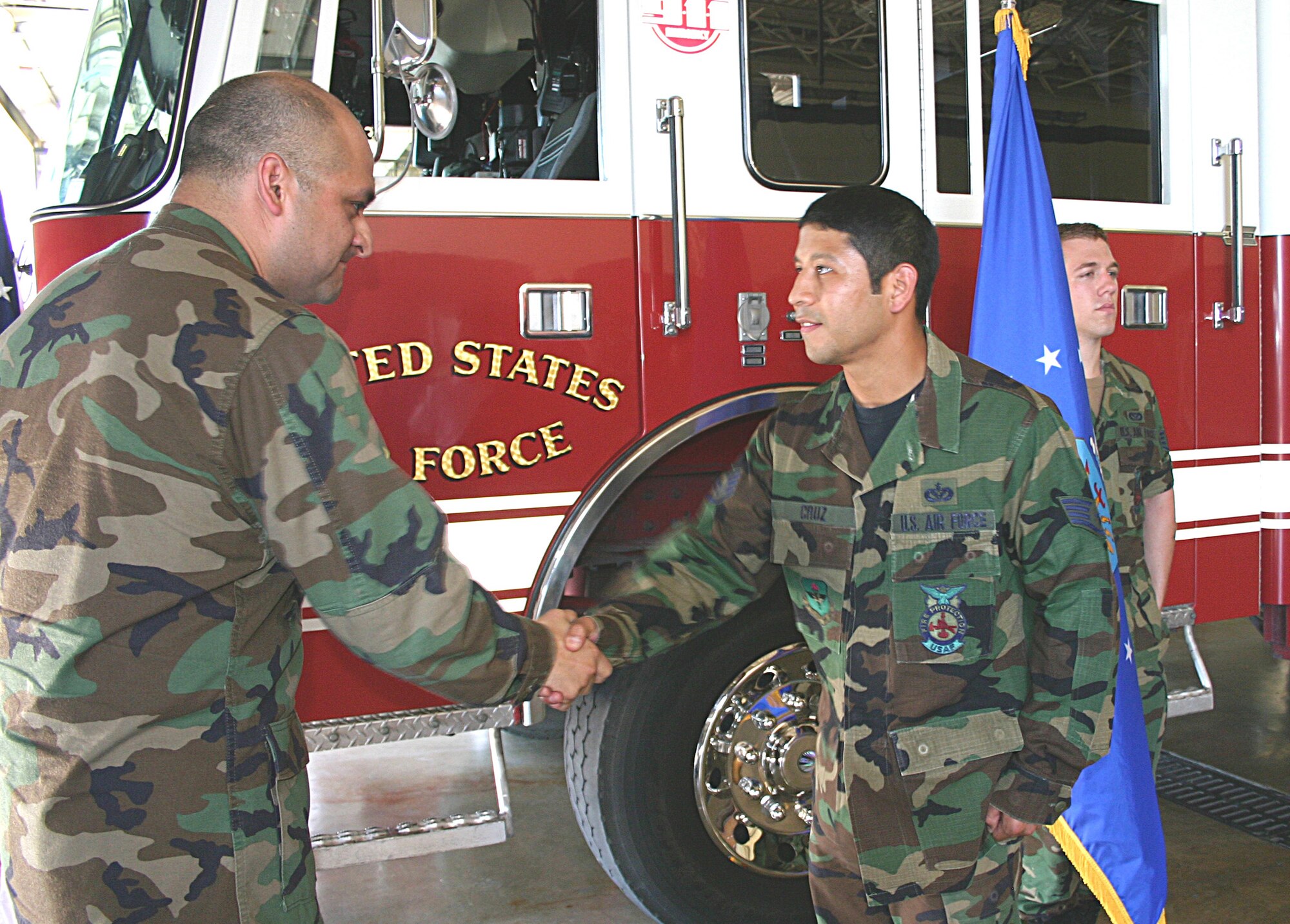 Capt. Homero Martinez, Air Force Recruiting Service Headquarters, shakes hands with Staff Sgt. Greg Cruz, 12th Civil Engineering Squadron, following Cruz’ reenlistment at Randolph AFB June 18.  Martinez brought Cruz into the Air Force when he was an enlisted recruiter back in 1998.  (Courtesy photo by Ms. Angelica Delgado)
