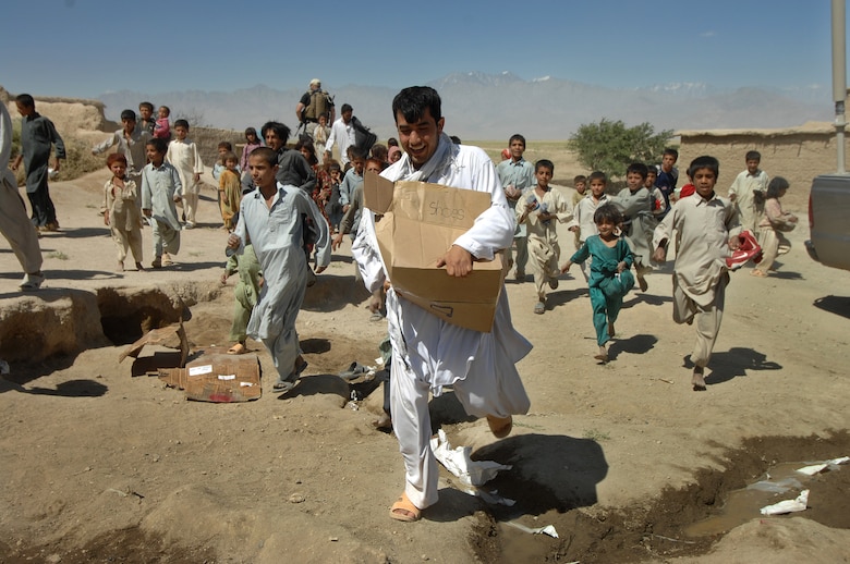 Children from the village of Qal' ehye Yuzbashi, Afghanistan chase after a young man carrying a box of shoes that was delivered June 17 by Lt. Gen. John Bradley. General Bradley, chief of the Air Force Reserve and Air Force Reserve Command commander, was delivering the supplies to the village located near Bagram Air Base. The supplies, destined for refugee camps, orphanages and hospitals throughout Southwest Asia, are part of the 9,000 pounds collected by General Bradley's wife, Mrs. Jan Bradley. General Bradley is visiting Airmen throughout Southwest Asia to thank them for their service supporting the war on terrorism. (U.S. Air Force photo/Tech Sgt. Rick Sforza)