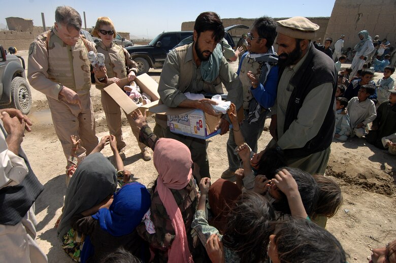 A group of children reach out for shoes that Lt. Gen. John Bradley is handing out June 17 in the village of Qal' ehye Yuzbashi in Afghanistan. General Bradley was delivering humanitarian supplies to the village located near Bagram Air Base. The supplies, destined for refugee camps, orphanages and hospitals throughout Southwest Asia, are part of the 9,000 pounds collected by General Bradley's wife, Mrs. Jan Bradley. General Bradley, chief of the Air Force Reserve and Air Force Reserve Command commander, is visiting Airmen throughout Southwest Asia to thank them for their service supporting the war on terrorism. (U.S. Air Force photo/Tech Sgt. Rick Sforza)