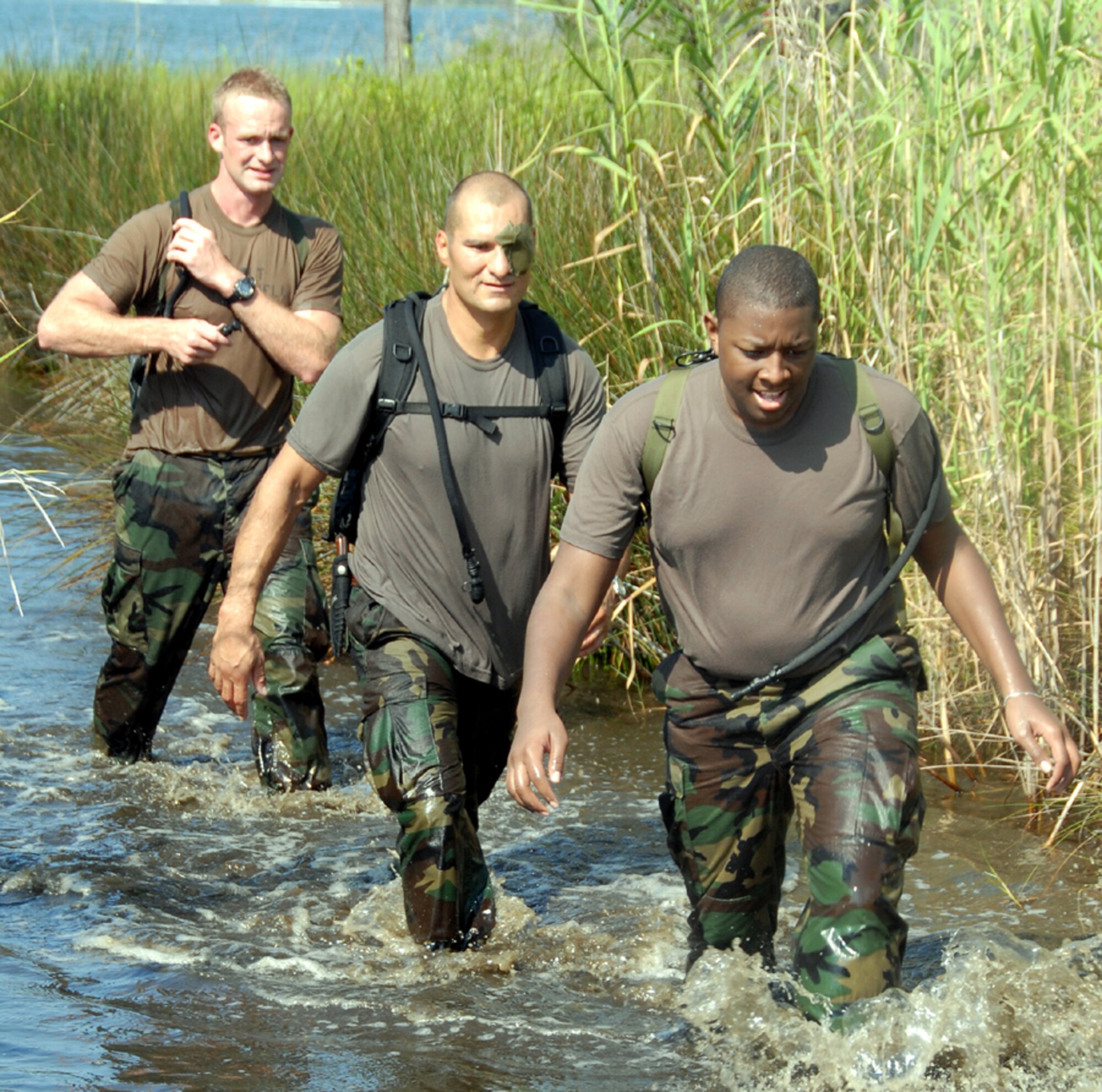Airyque Ervin makes his way through stagnant water during a grueling special tactics “Monster Mash” competition June 14 at Hurlburt Field.  He is followed by his teammates, Capts. Frank Rodriguez and Eli Mitchell of the 720th Operational Support Squadron Advanced Skills Training Center.  Airyque, who spent two days earning Honorary Air Commando honors as a Make-A-Wish recipient, is from Vallejo, Calif.  (U.S. Air Force photo by Chief Master Sgt. Gary Emery)
