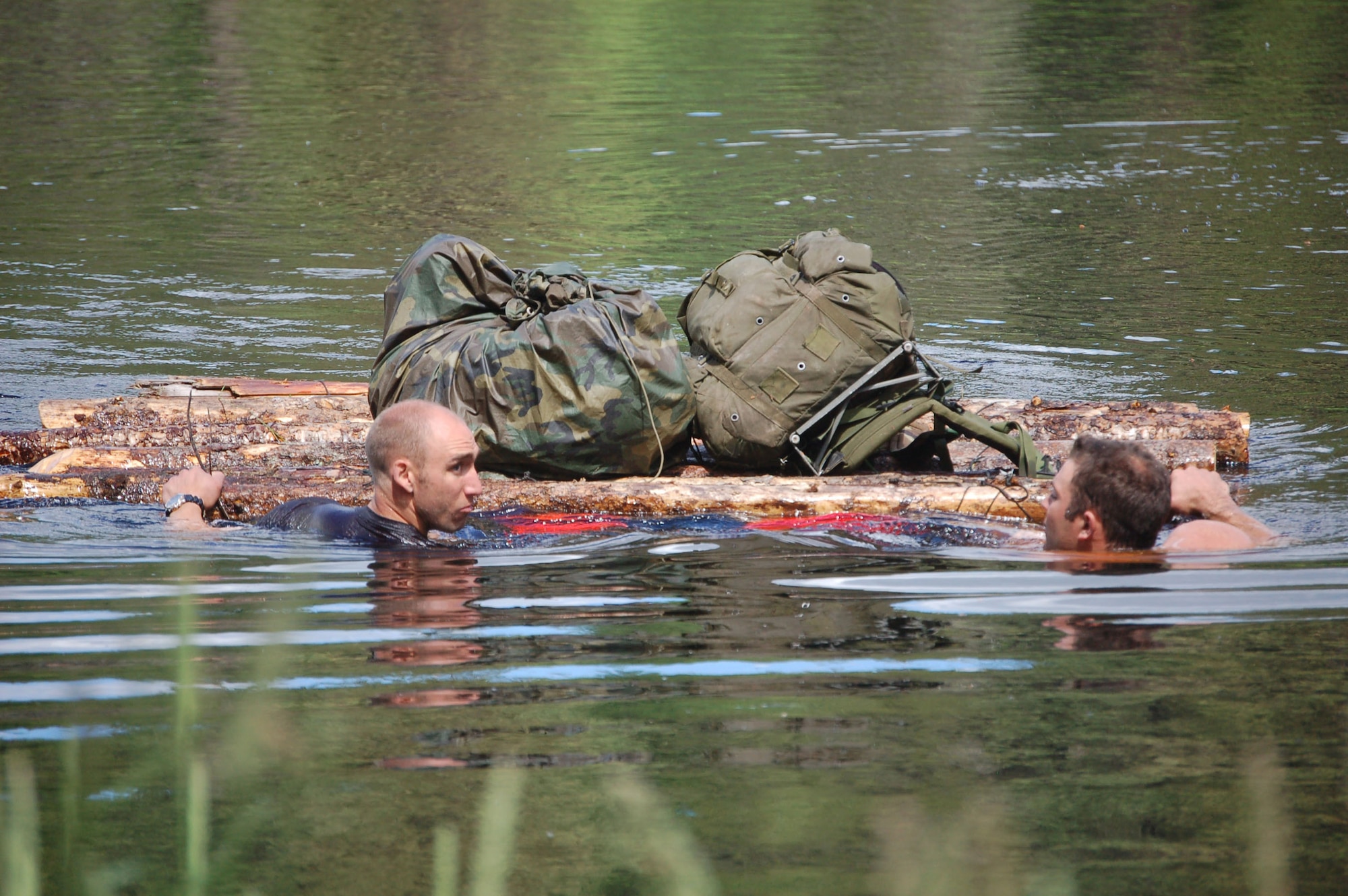 Staff Sgt. Michael Garcia and Staff Sgt. Matthew Zimmer, competitors in the 2007 SERE (survival, evasion, resistance and escape) Challenge, swim across a frigid pond in Colville National Forest near Fairchild Air Force Base, Wash. The sergeants, both SERE specialists at Fairchild AFB, were pushing a raft they constructed to keep their gear dry. The task was one of many skill sets the 15 teams had to master during the competition. Finishing first, the team won the Col. Bud Day trophy. (U.S. Air Force photo/Staff Sgt. Matthew Rosine)