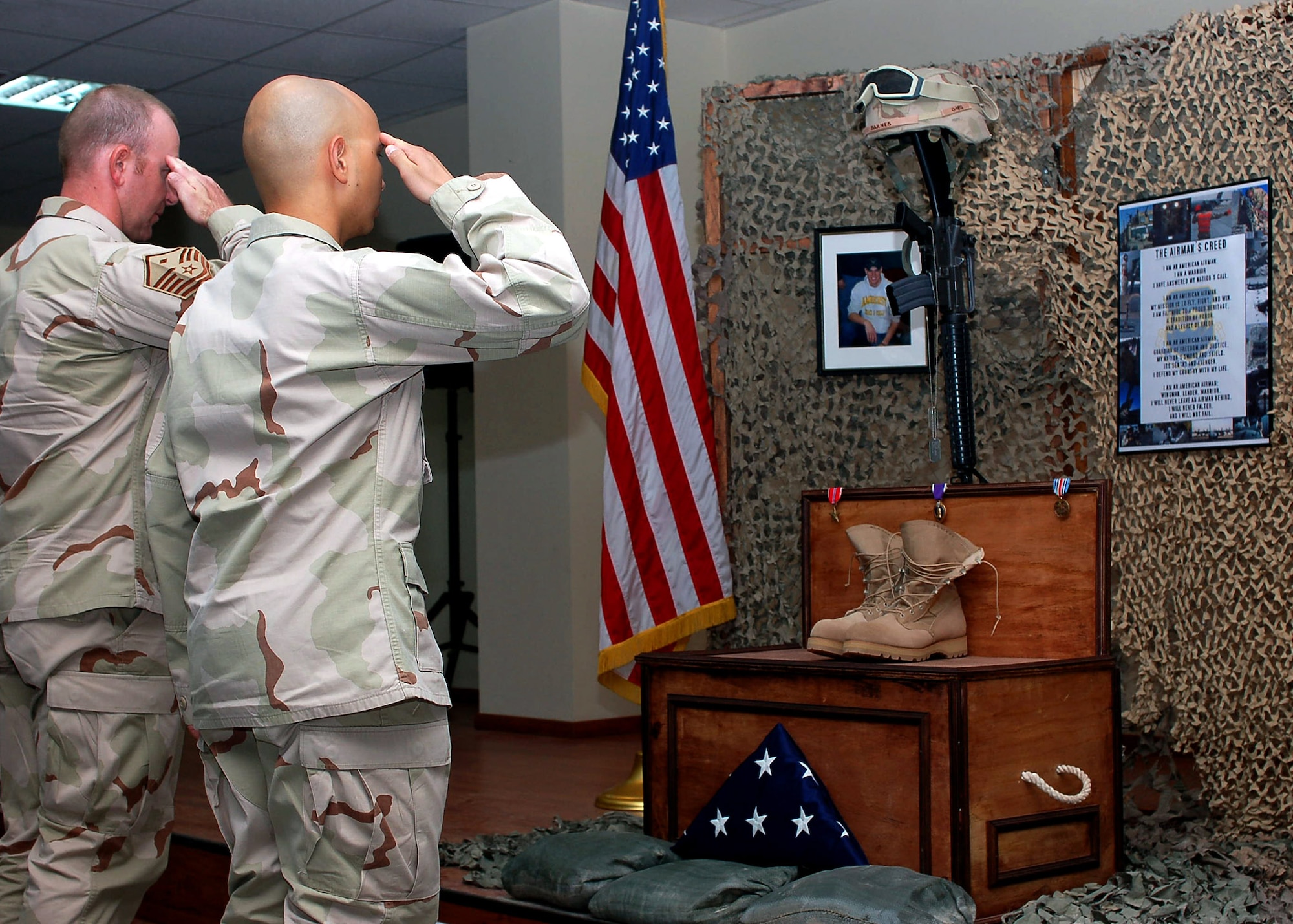 386th Air Expeditionary Wing Airmen salute a memorial display, June 15, after a ceremony held in honor of Airman 1st Class Eric Barnes, who was killed in action while on a convoy mission in support of Operation Iraqi Freedom. The ceremony was the first of two held at different locations in Southwest Asia. Airman Barnes was on his second deployment to the 424th Medium Truck Detachment.  (U.S. Air Force photo/Staff Sgt. Raymond Mills)