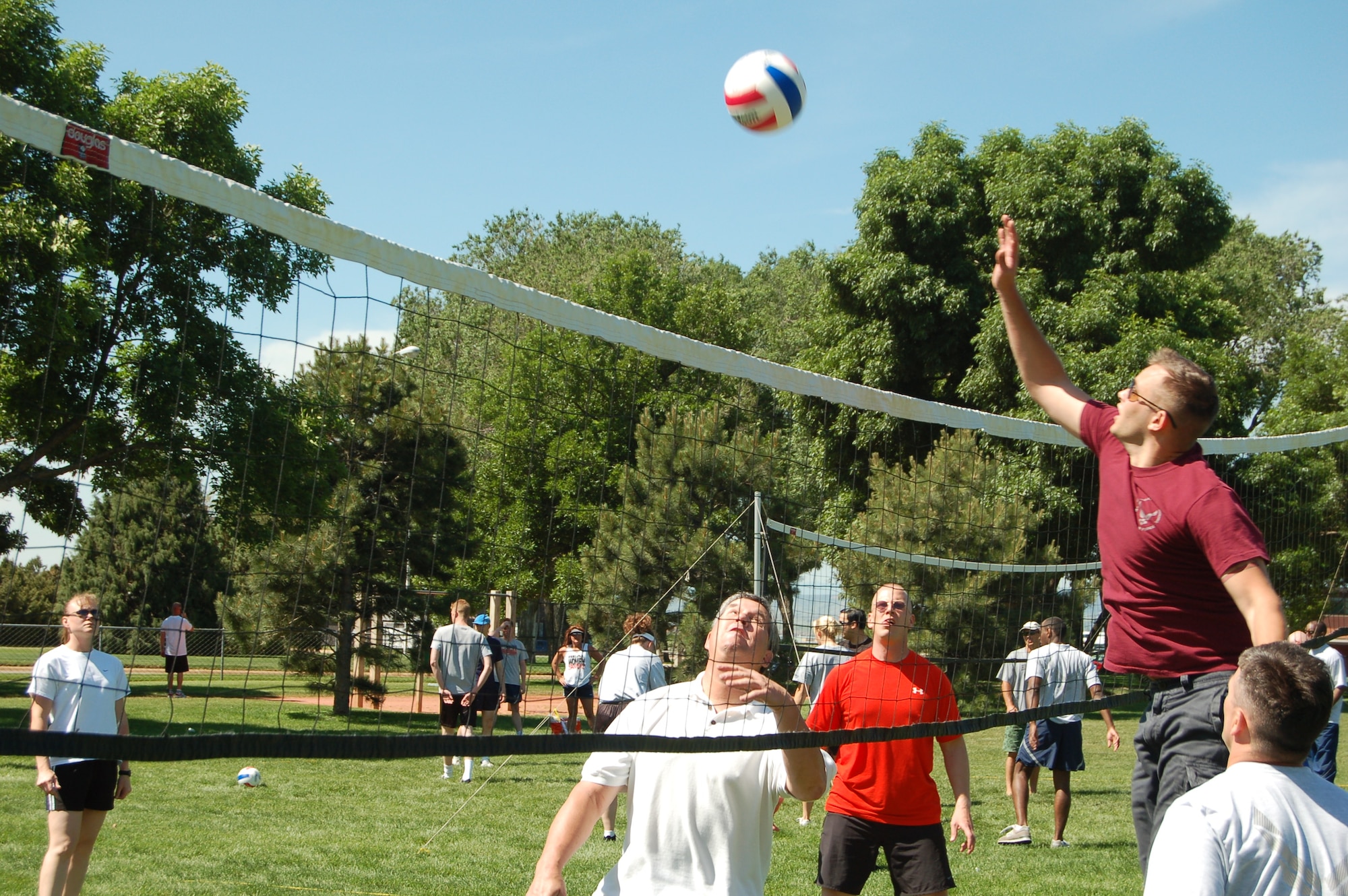 A volleyball player spikes the ball during Peterson's Sports and Field Day June 14. Volleyball was just one of many activities offered during the day-long event, which was meant to encourage fitness for all base employees. (U.S. Air Force photo by Corey Dahl)