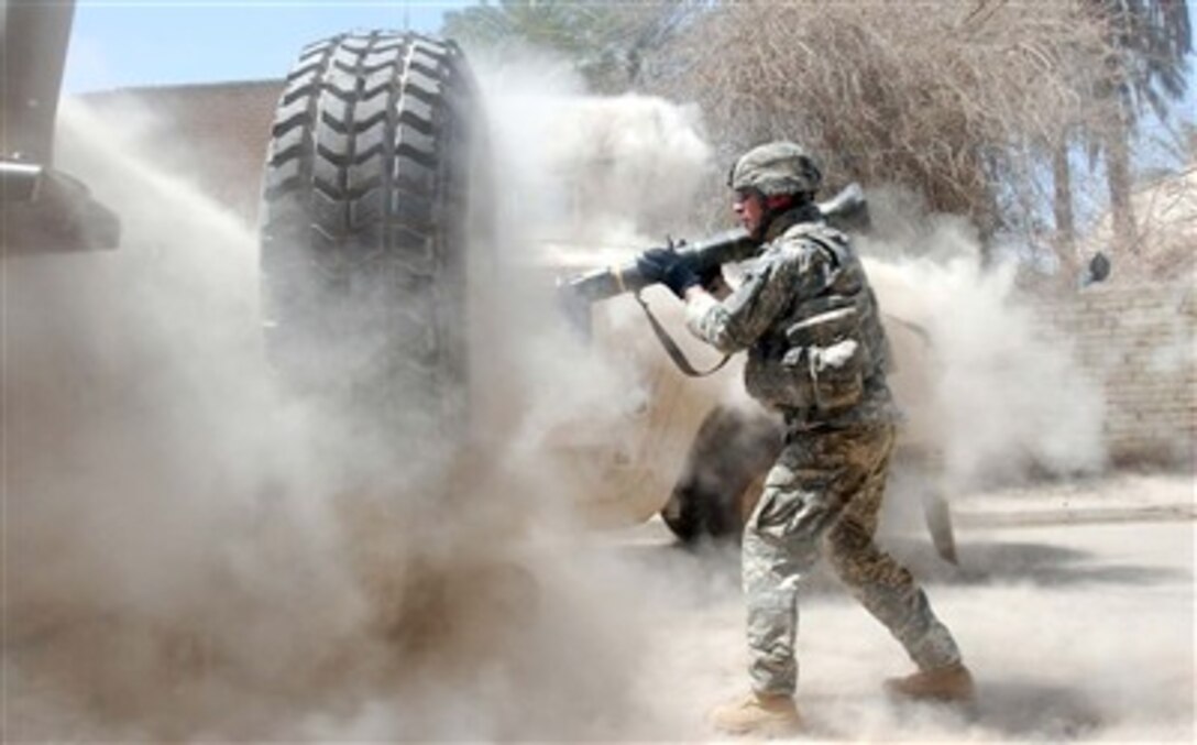 A cloud of smoke and dust envelopes U.S. Army Staff Sgt. Michael Mullahy seconds after he fired an AT-4 rocket launcher at an insurgent position during a firefight in Baghdad's Adhamiyah neighborhood June 16 which ended with one insurgent dead and three captured. Mullahy is a squad leader with Charlie Company, 1st Battalion, 26th Infantry Regiment.
