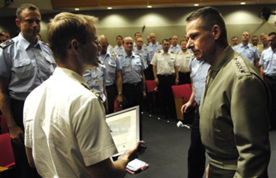 Chairman of the Joint Chiefs of Staff Marine Gen. Peter Pace accepts a painting from a student of the visiting German Joint Armed Forces Command and Staff College class, at the Pentagon, June 19, 2007, after discussions ranging from the war on terror to military transformation. 