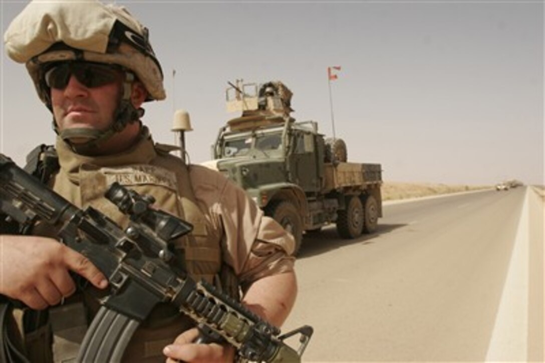 U.S. Marine Corps Lance Cpl. Robert Wayne Rapp keeps his weapon ready as he performs a dismounted patrol around his seven-ton truck during a security halt in Al Asad, Iraq, on June 11, 2007. Rapp is a motor transportation operator with the Transportation Support Company, Combat Logistics Battalion 2, 2nd Marine Logistics Group.  