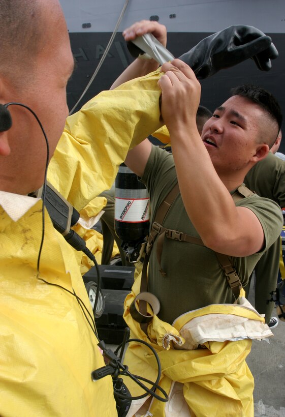 NAVAL AMPHIBIOUS BASE CORONADO, SAN DIEGO ? Lance Cpl. Daniel J. Yeam (right), from Chicago, applies tape to the wrist of Lance Cpl. Javier Aguirre, from Vallejo, Calif., before entering the USS Tarawa to conduct a vessel boarding search and seizure mission June 19, here. Marines and sailors from Battery G, Battalion Landing Team 1st Battalion, 5th Marine Regiment, 11th Marine Expeditionary Unit took part in a three-week training exercise in order to provide the 11th MEU with a confined space, site exploitation capability that can respond to a chemical, biological, radiological or nuclear incident. Yeam is a CBRN defense specialist and Aguirre is a field wireman with with BLT 1/5, 11th MEU.