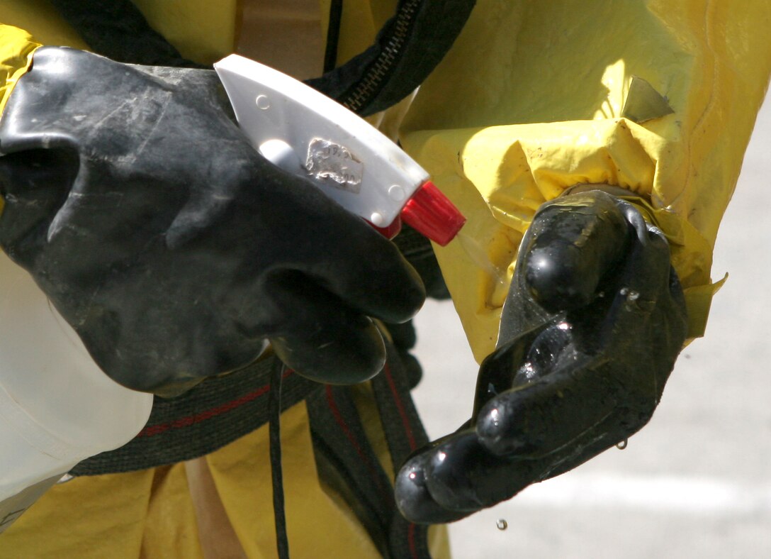 NAVAL AMPHIBIOUS BASE CORONADO, San Diego ? Members of the 11th Marine Expeditionary Unit?s Enhanced Chemical, Biological, Radiological and Nuclear Defense Team spray each others chemical protective suits with a bleach-water mix to get rid of any toxic agents that might be on the suit during the decontamination process after a Vessel Boarding Search and Seizure exercise June 19, here.