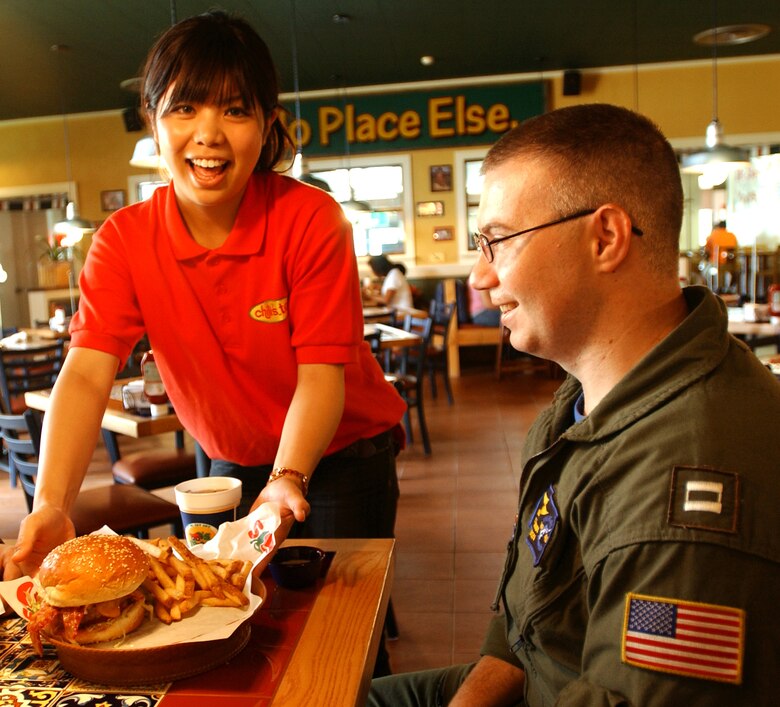 Yuriko Makamura, a Chili's Too employee, serves a patron lunch. The restaurant opened June 18 at Kadena Air Base, Japan. The base hosts one of the busiest Chili's resturants in the world. Chili's Too is a smaller scale restaurant serving the same quality of food as the main restaurant, but faster.  (U.S. Air Force photo by Staff Sgt. Reynaldo Ramon)

