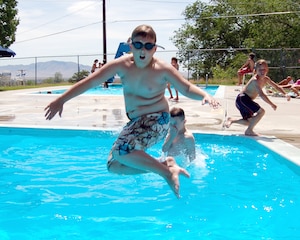 June 21 is the first official day of summer, although the temperatures have already reached the high 90s. Hill Air Force Base kids have taken advantage of the warm weather, such as Tristan Pendley, 11, who jumps into one of the base swimming pools. (U.S. Air Force Photo by Beth Young)