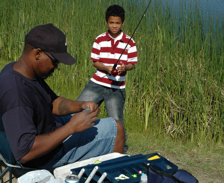 Little Warrior Marion, 10, gets the line on his fishing pole fixed by his dad, Damen, during the 2nd Annual Kid’s Fishing Day at Pow Wow Park Saturday. The members of the 341st Civil Engineer Squadron arranged for the pond to be stocked with 200 rainbow trout June 15 and more than 100 people attended the family day event. Prizes were awarded for the biggest catches of the day. (U.S. Air Force photo/Senior Airman Eydie Sakura)

