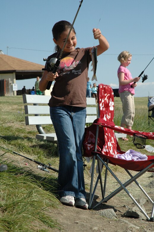 Little Warrior Morgan, 9, catches her first fish of the day at the 2nd Annual Kid’s Fishing Day Saturday at Pow Wow Park. (U.S. Air Force photo/Senior Airman Eydie Sakura)