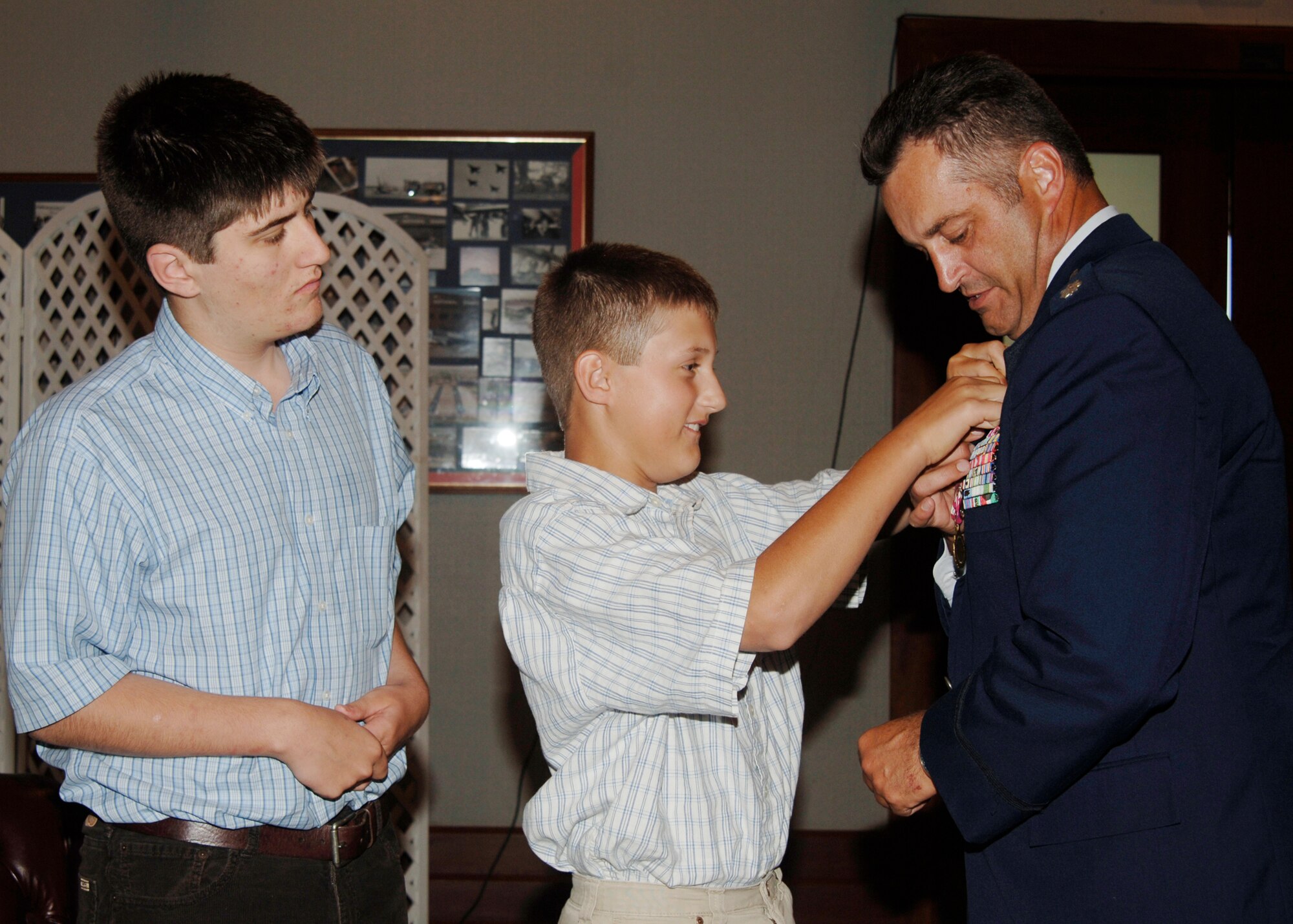 Matthew, 14, and Michael, 12, sons of Lt. Col. Mark McClain former 22nd Air Refueling Wing Director of Staff, help fasten a retirement pin on him during his retirement ceremony in Signatures lounge June 15. (Photo by Senior Airman Jamie Train)