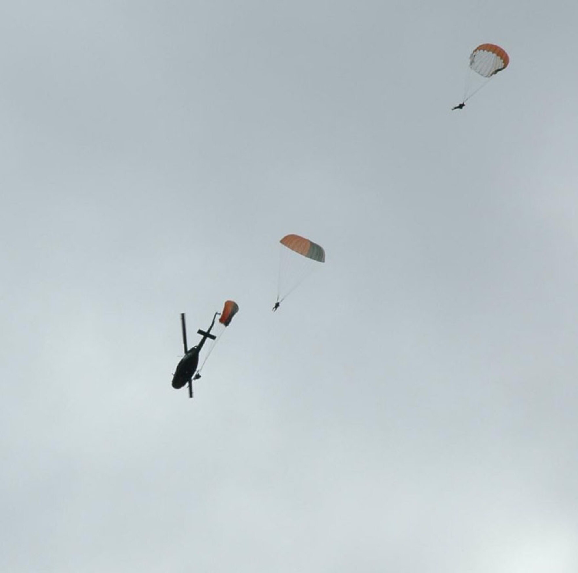 Students practice static line parachuting techniques from a UH-1N "Huey" assigned to the 36th Rescue Flight, Fairchild AFB, Wash. The jumpers are performing demo drops for students attending survival school. The 36 RQF supports this school, along with SERE Specialist Training -- and also responds to civilian search and rescue requests through the National Search and Rescue Plan.  (U.S. Air Force photo)