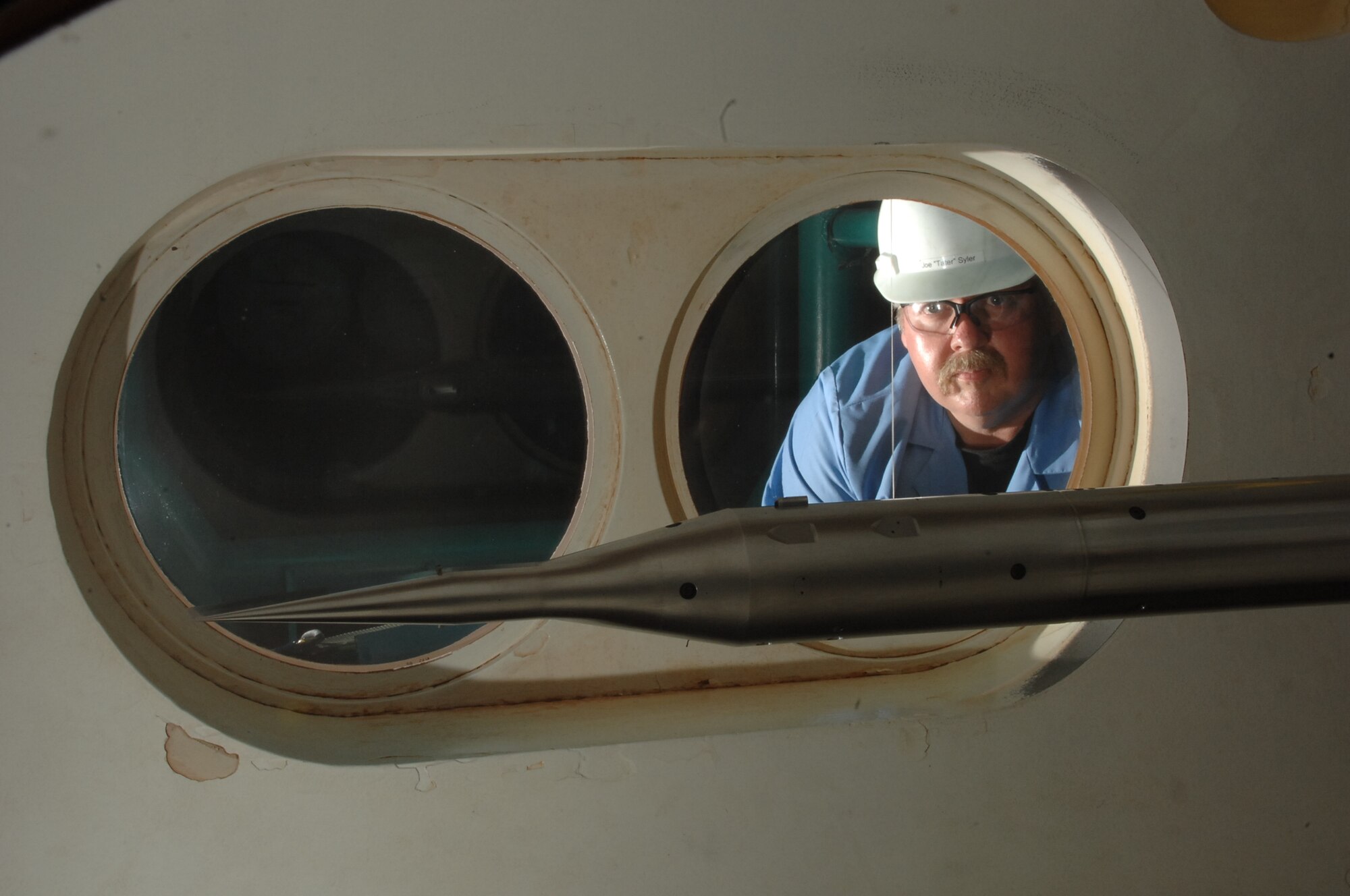 Joe Syler, Tunnel B operations crew member, watches a model of the NASA Hypersonic Boundary Layer Transition (HyBoLT) rocket as it is prepared for testing at Mach numbers of 6 and 8 in Arnold Engineering Development Center’s von Karman Gas Dynamics Facility’s Tunnel B. (Photo by David Housch)
