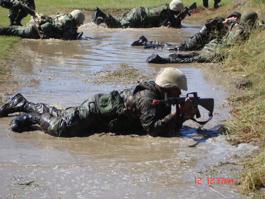 Students high crawl through the mud during Expeditionary Combat Skills Training. The full training course includes a day and a half of classroom instruction and a day and a half  field training at Warrior Air Base on Robins. (Courtesy photo)