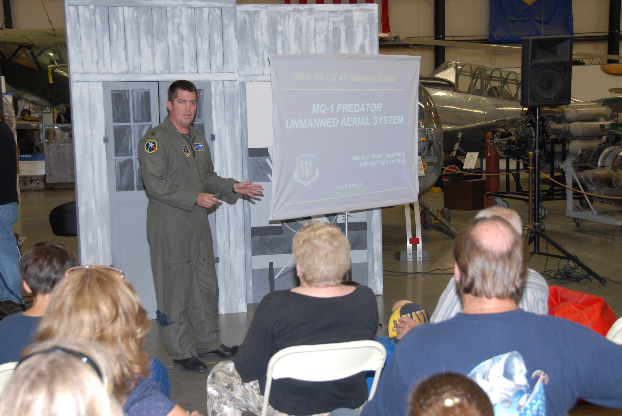 Maj. Eric Fagerland, a 163d Reconnaissance Wing Predator Pilot, conducts a mission briefing at the March Field Air Museum during an Open Aircraft Day this month. (U.S. Air Force photo by Staff Sgt. Eduardo Cervantes)