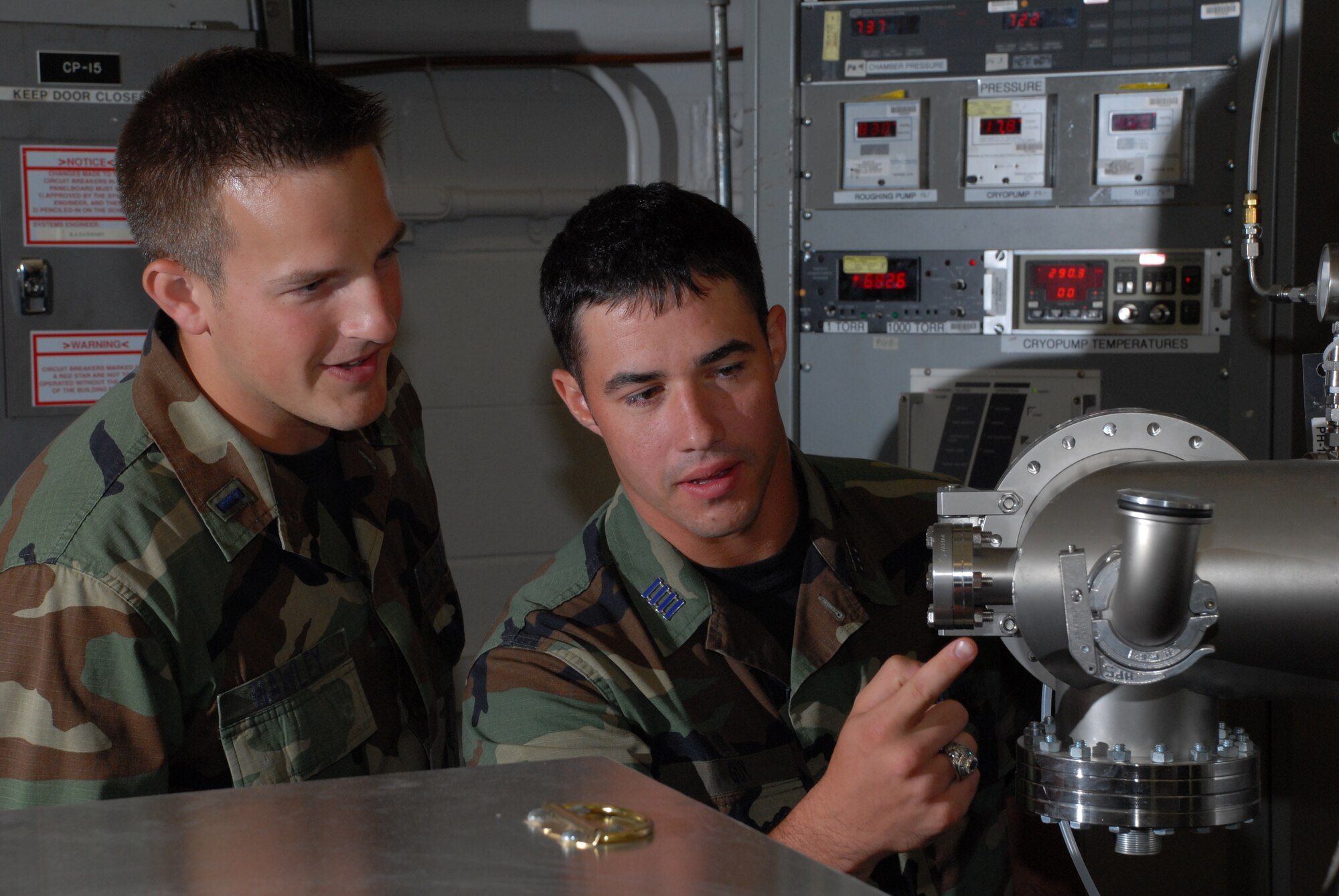 1st Lt. Ryan Hawley and Air Force Academy Cadet Greg Guy observe the critical pressure changes in AEDC's small vacuum research chamber. (Photo by Rick Goodfriend)